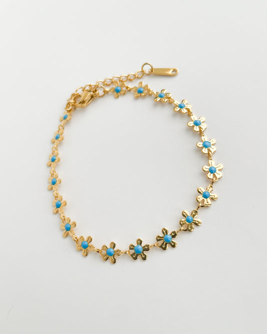 Gold bracelet with turquoise stones on a light gray background. Azul Daisy Bracelet