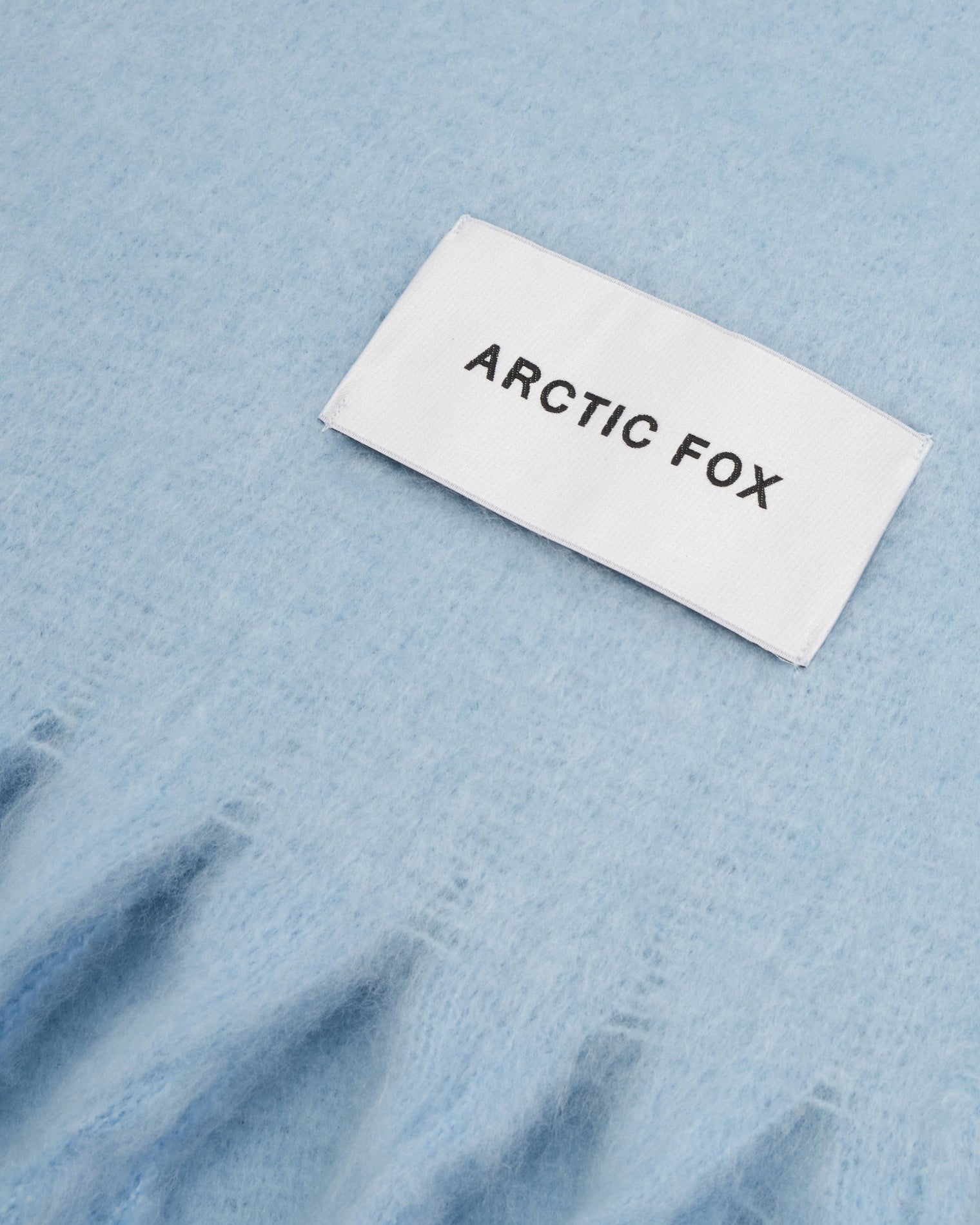 Label with 'Arctic Fox' text on a blue scarf