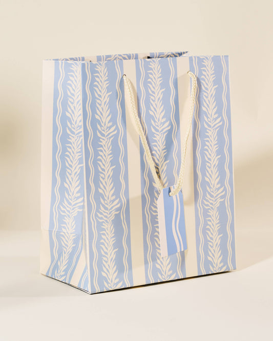 Gift bag with blue and white striped pattern on a beige background