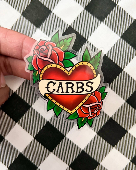 Heart-shaped sticker with roses and 'CARBS' text held over a checkered background