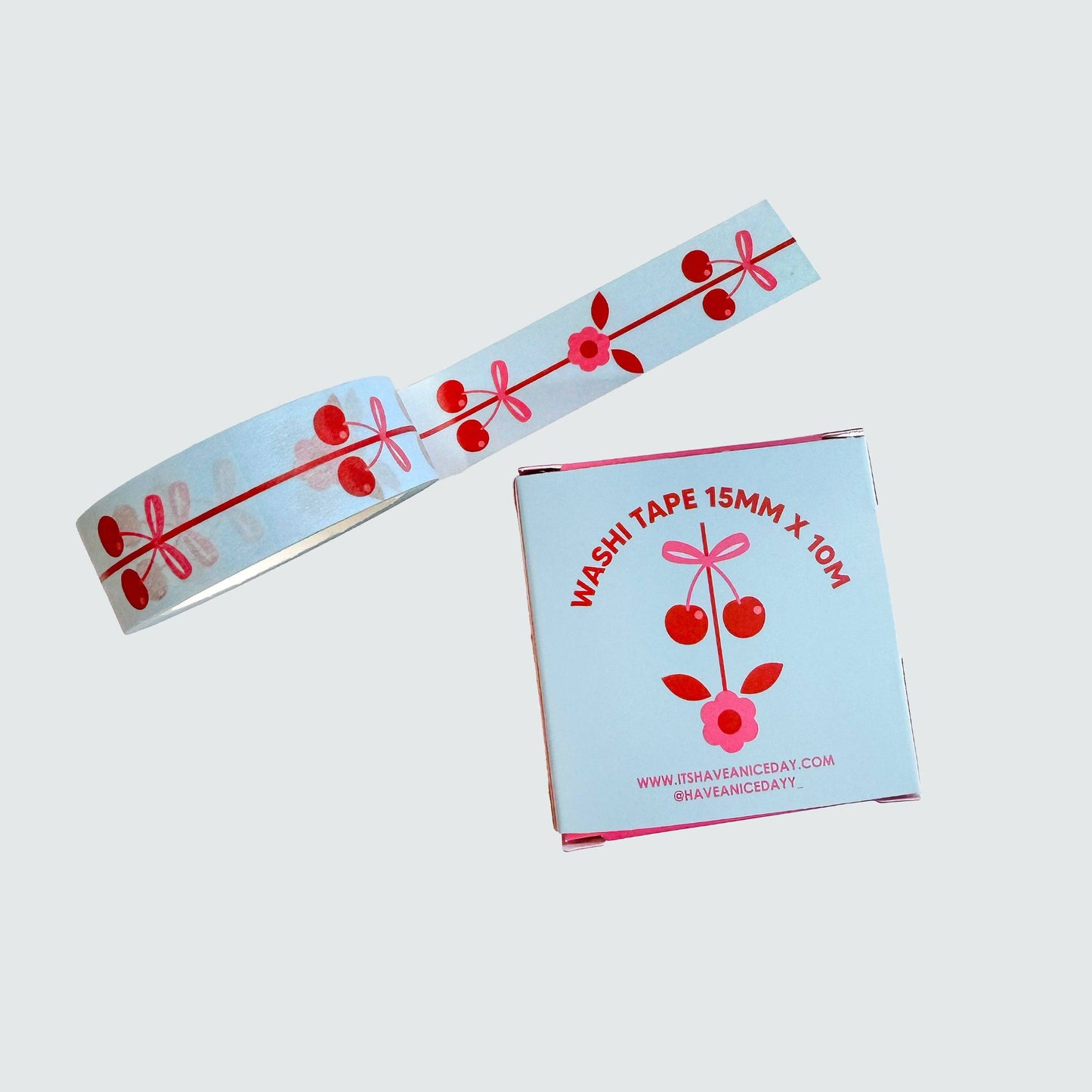 Two rolls of washi tape with cherry designs on a light gray background