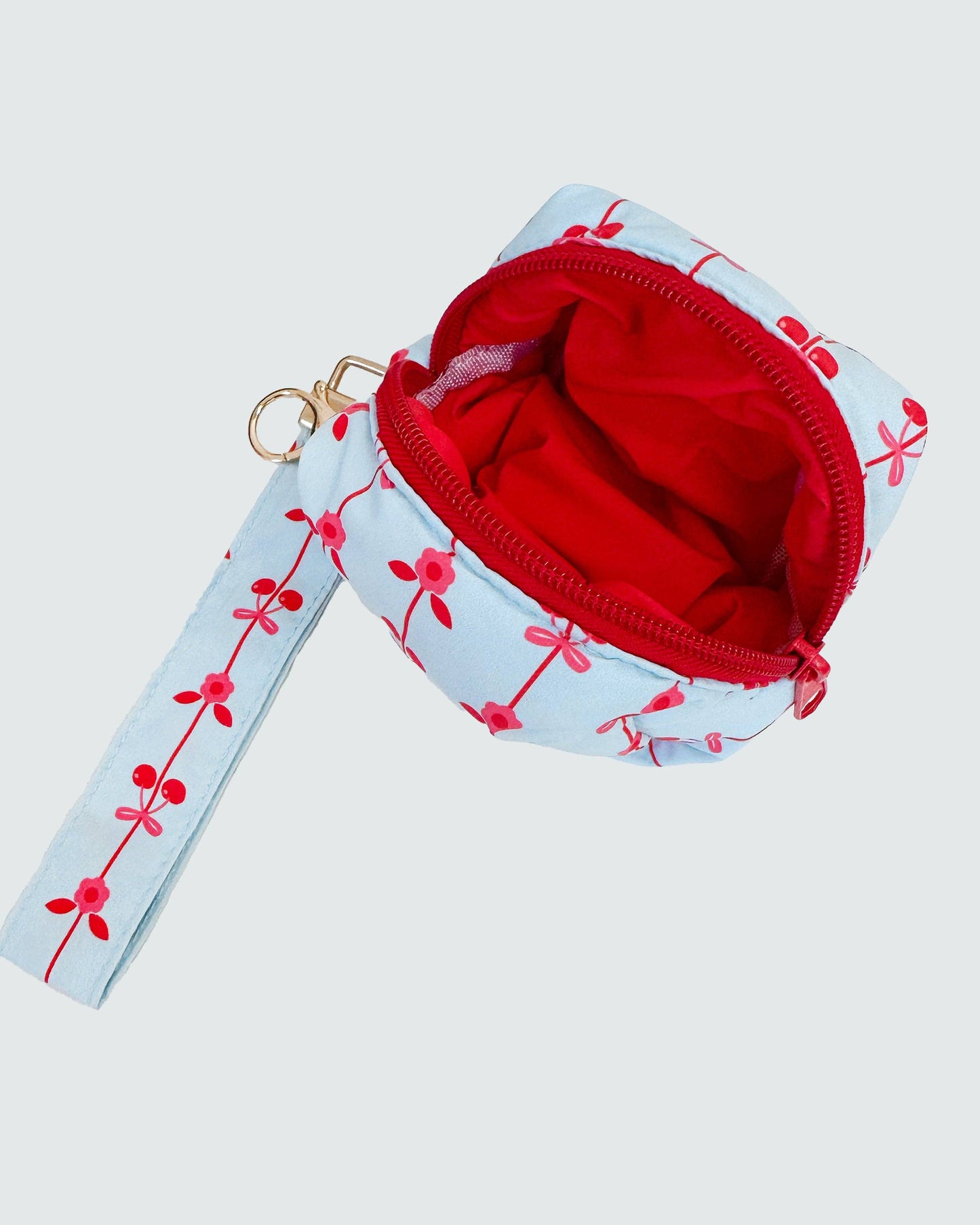 Small pouch with floral strap on a light gray background