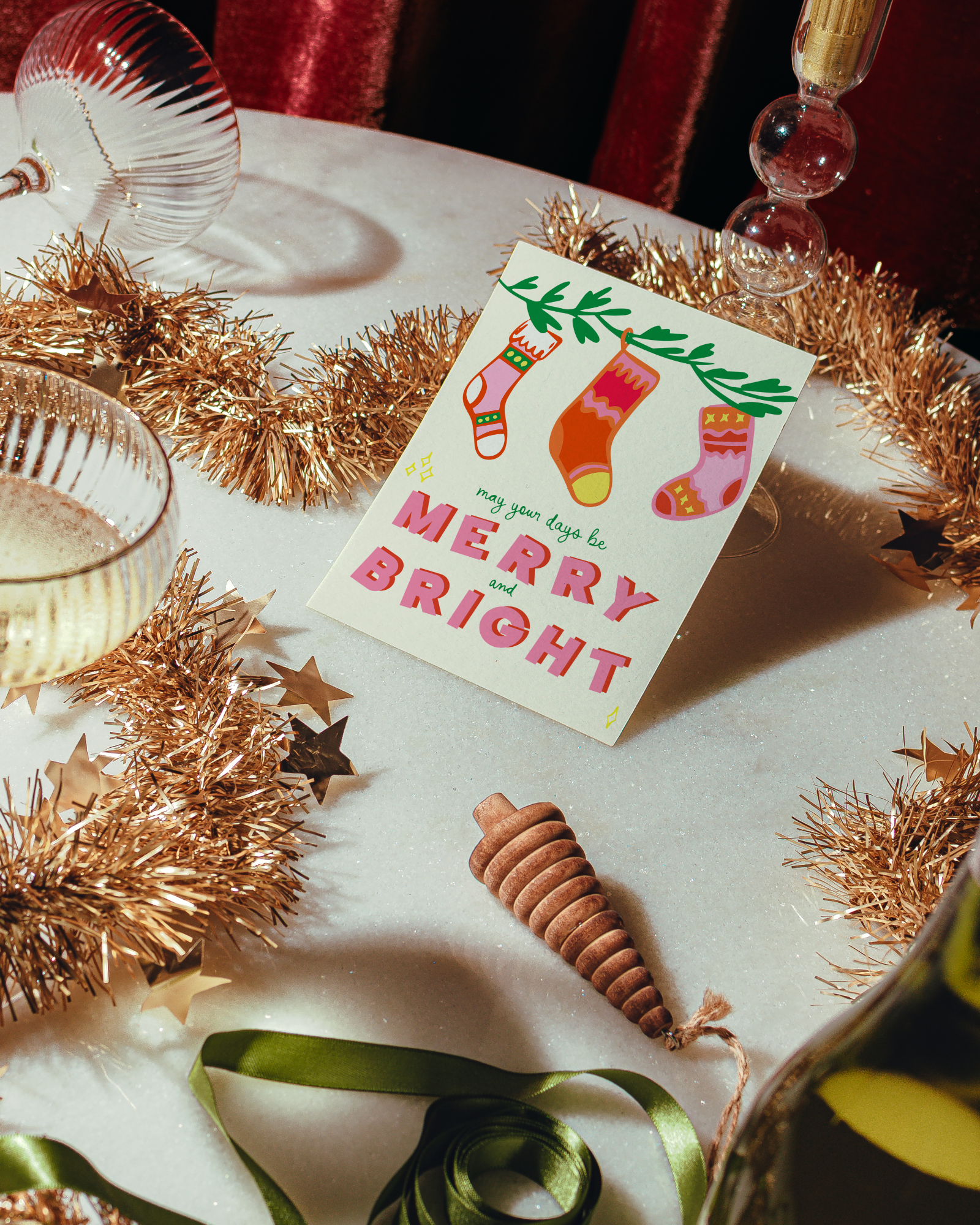 Christmas card with colorful socks and 'Merry Bright' text on a table with festive decorations. Days be Merry & Bright Holiday Greeting Card
