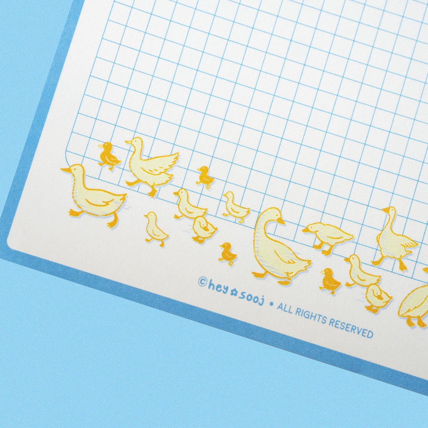 Sheet of paper with duck illustrations on a blue background