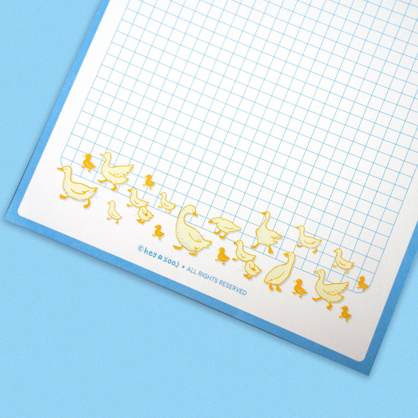 Notebook with gold duck illustrations on a blue background