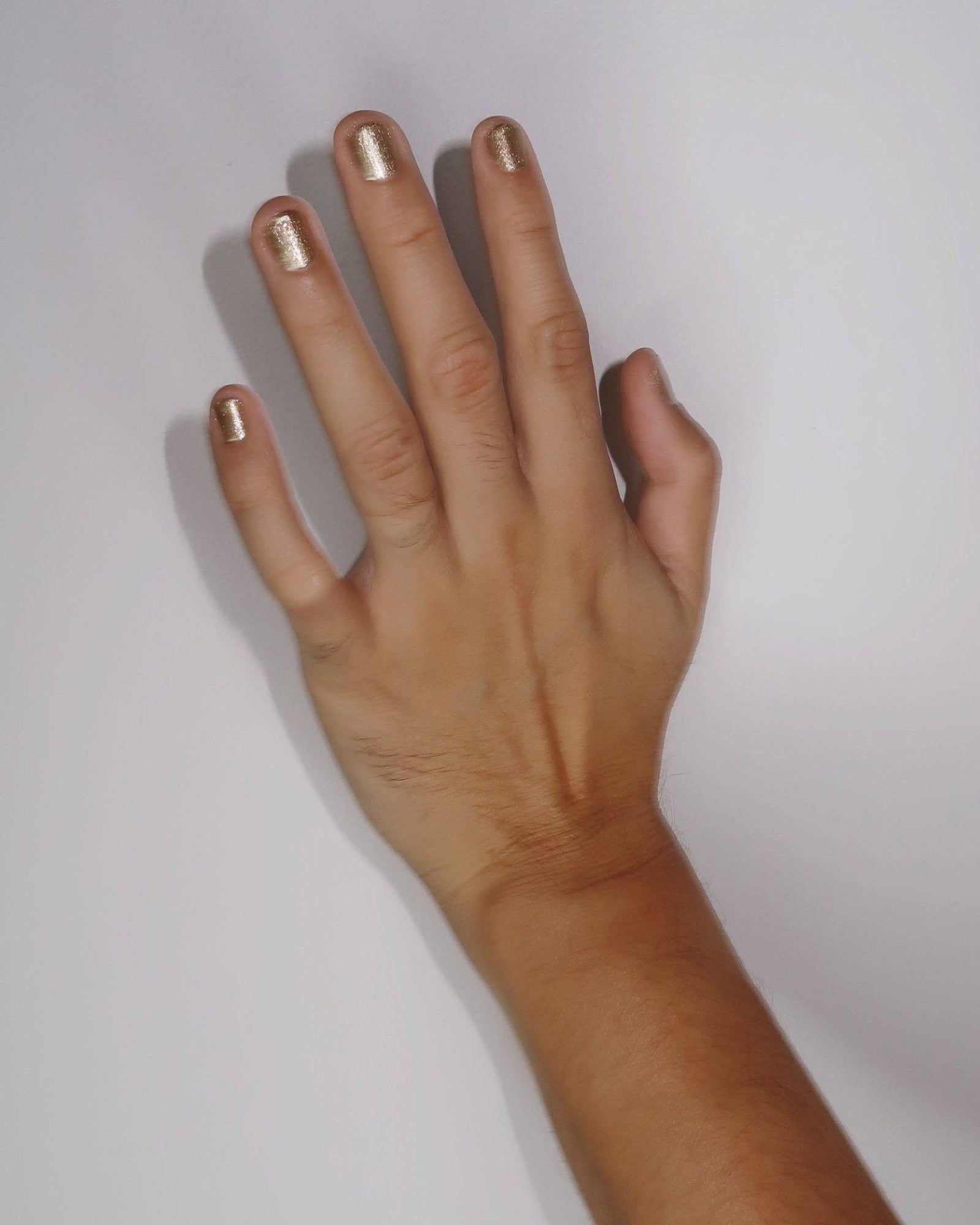 Hand with painted nails on a white background