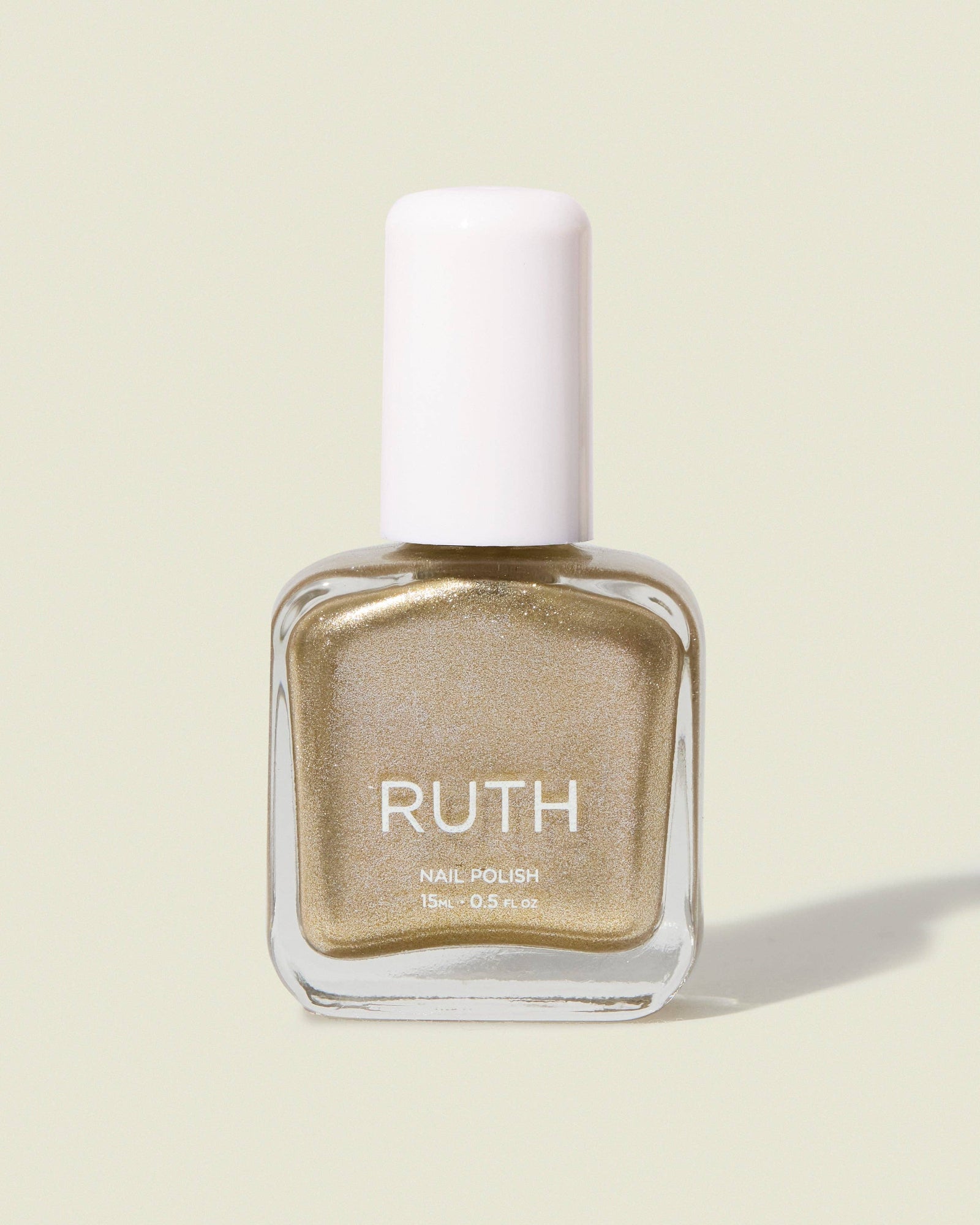 Gold nail polish bottle with white cap on a light beige background, Fizzy Silver Gold Nail Polish