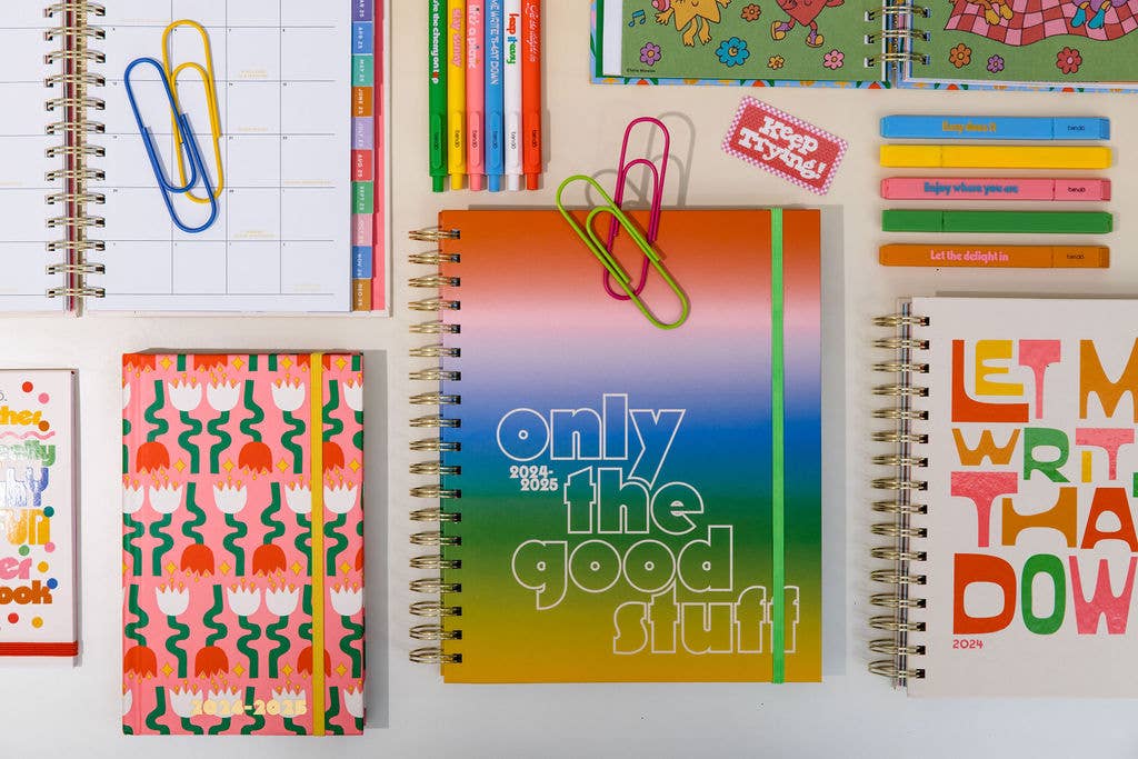 Assorted stationery items including notebooks, paper clips, and stickers on a white surface.