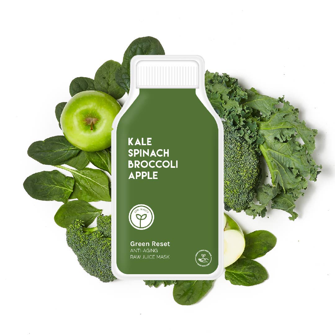 Green Reset juice mask surrounded by kale, spinach, broccoli, and an apple on a white background