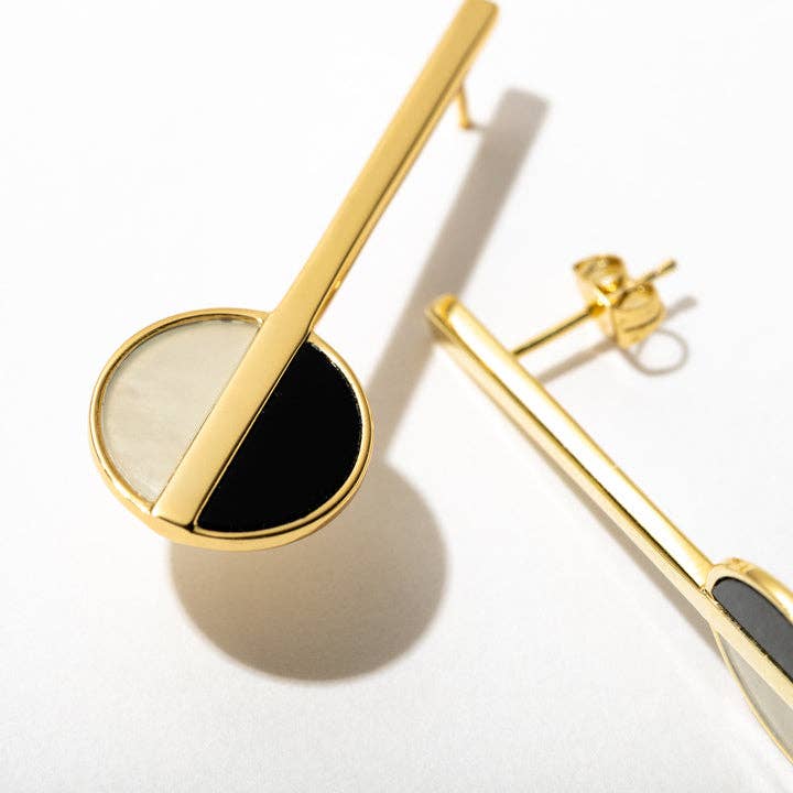 Gold and black earrings on a white background