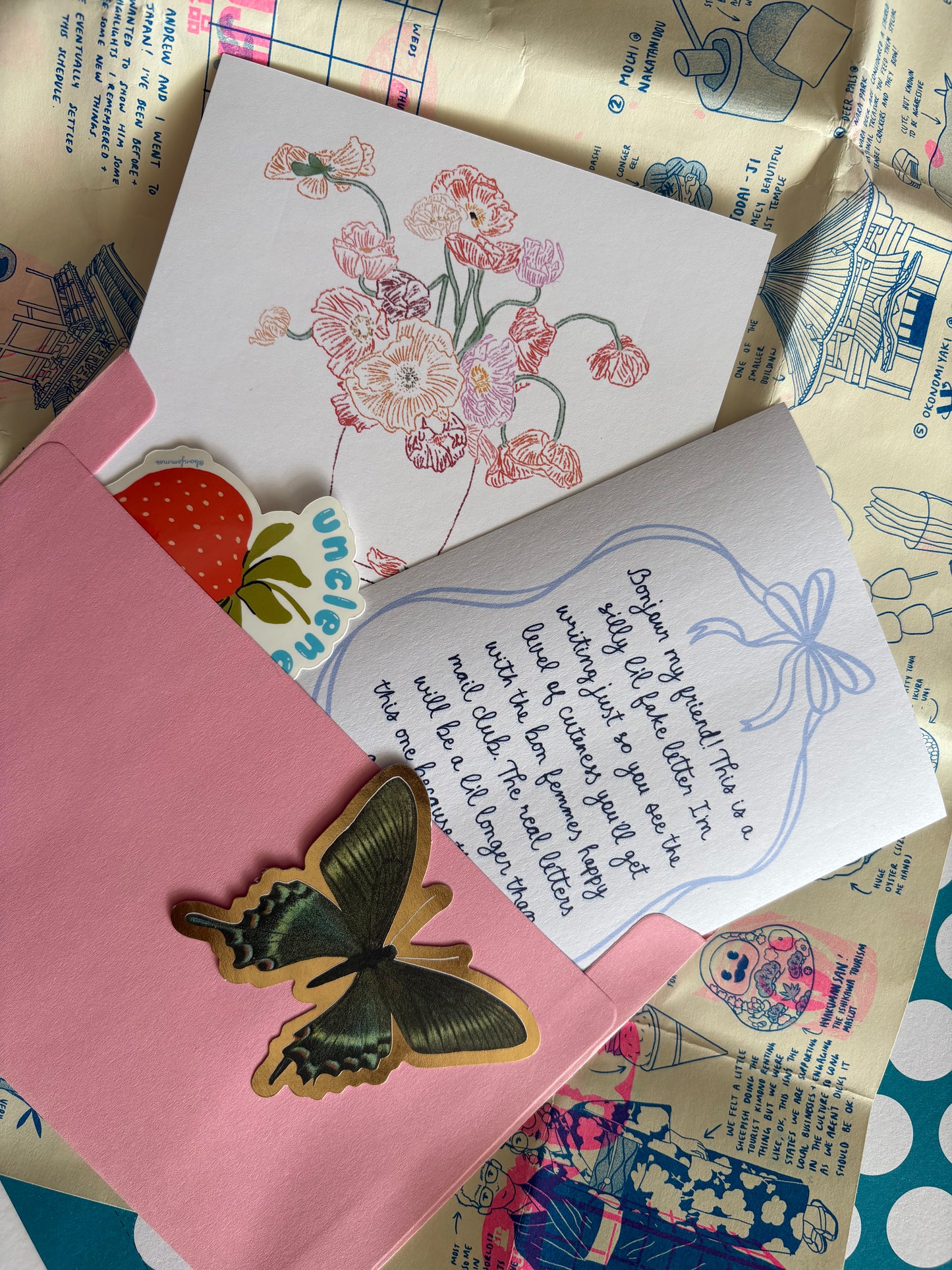 Floral card, letter, and butterfly ornament on a patterned surface, Happy Mail by Bon Femmes