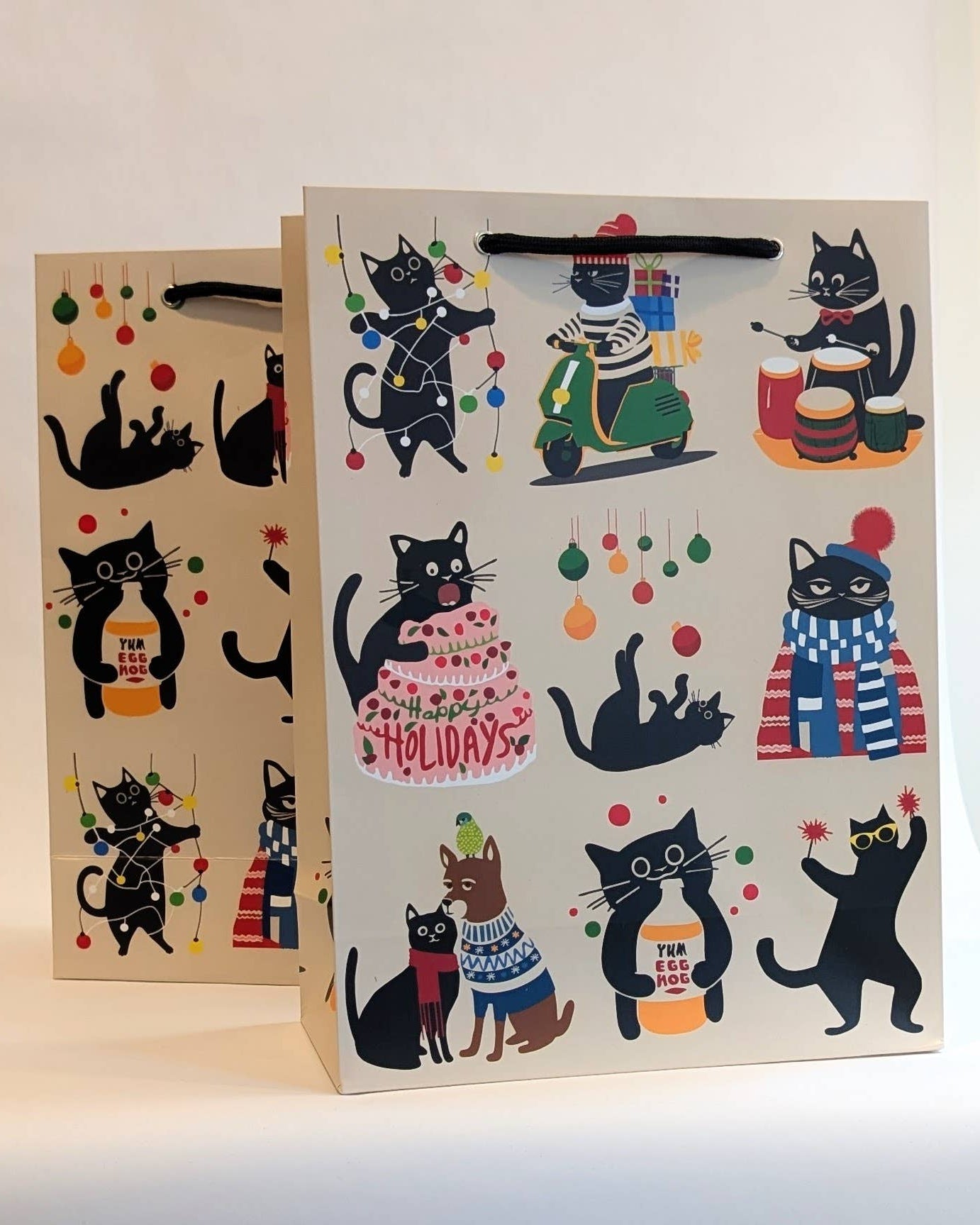 Two gift bags with black cat illustrations on a white background