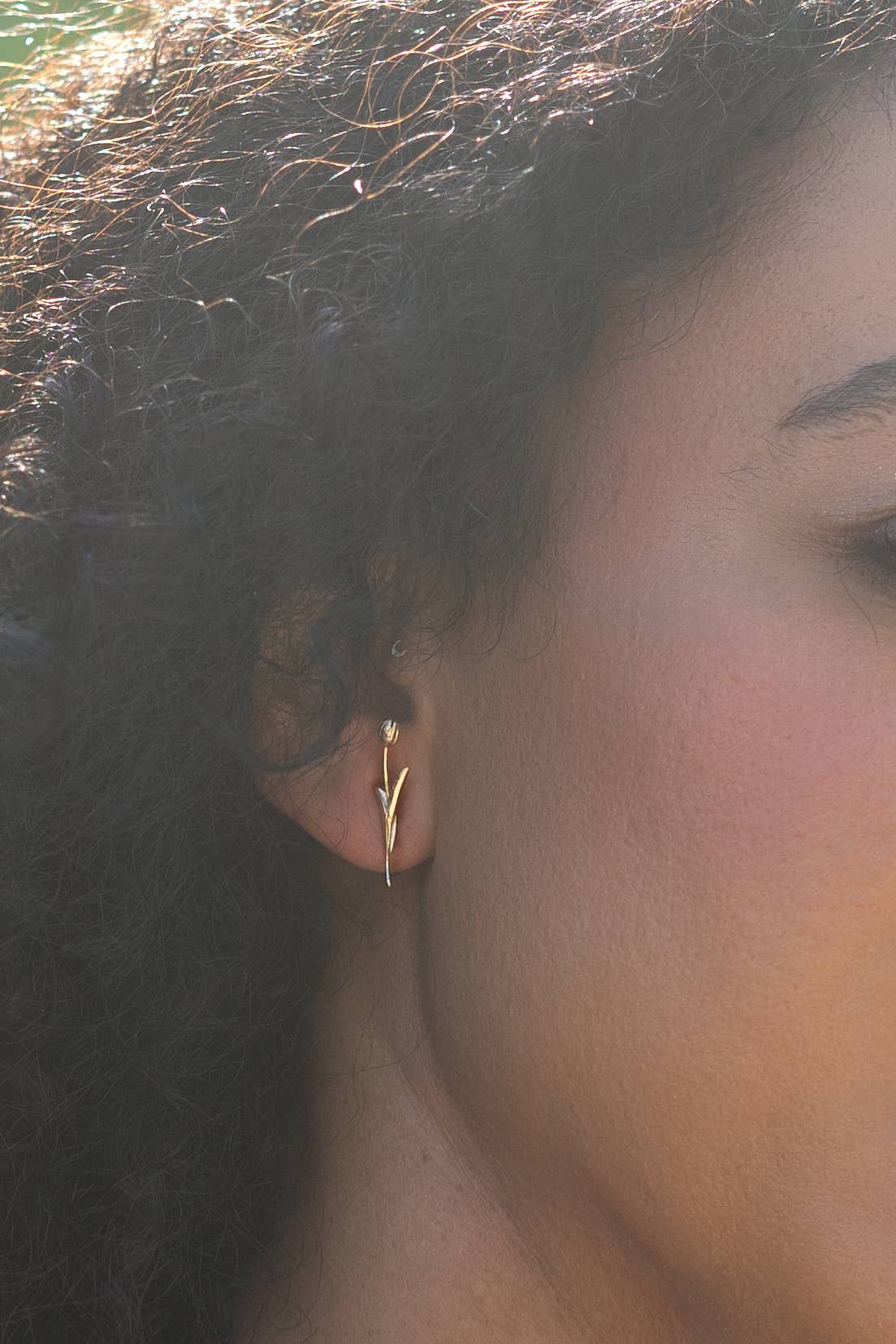 Close-up of a person wearing a gold earring with a blurred background, Holland Tulip Stud Earrings in Silver