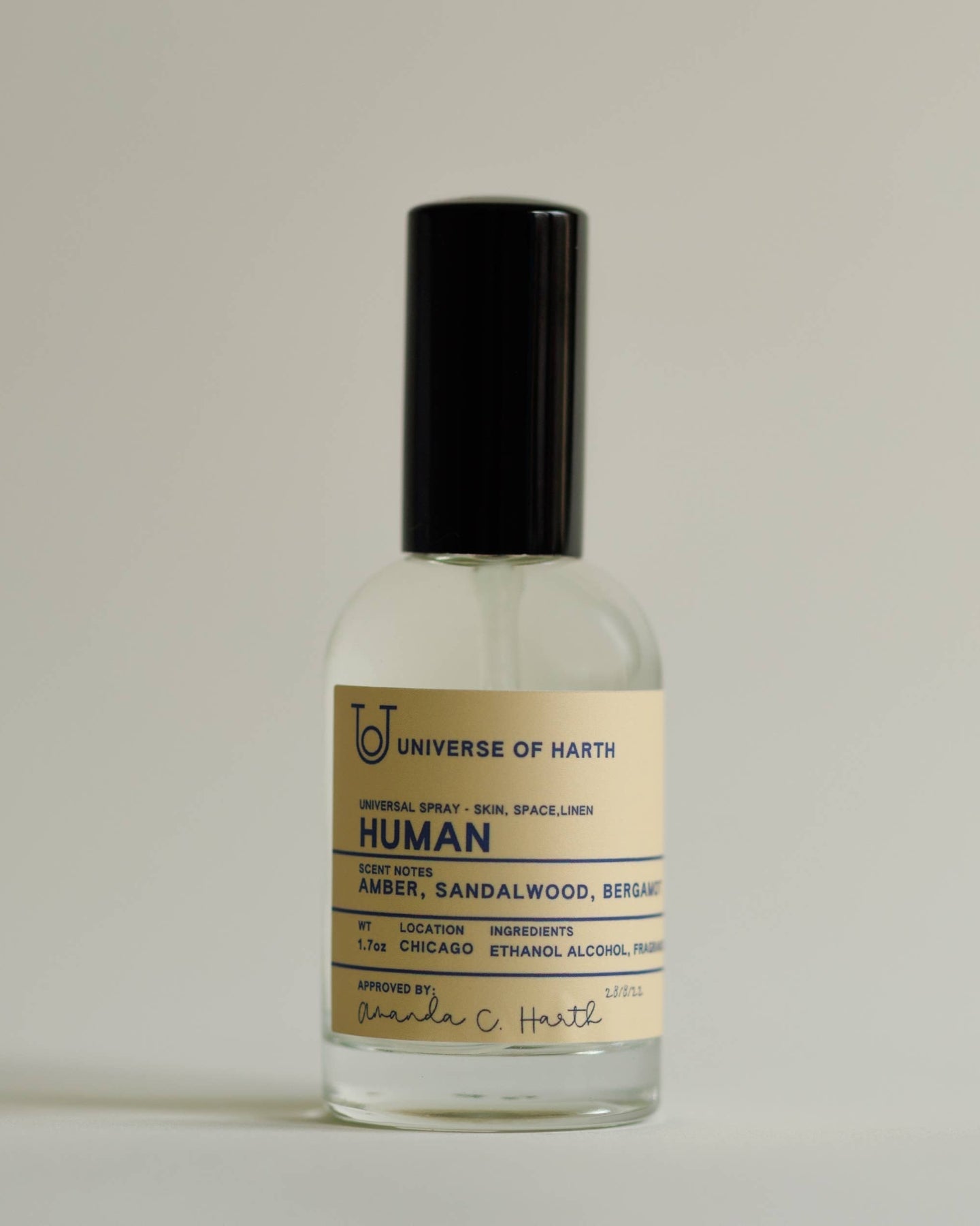 Small glass bottle with a black cap on a light gray background, Human: Room, Space and Body Spray