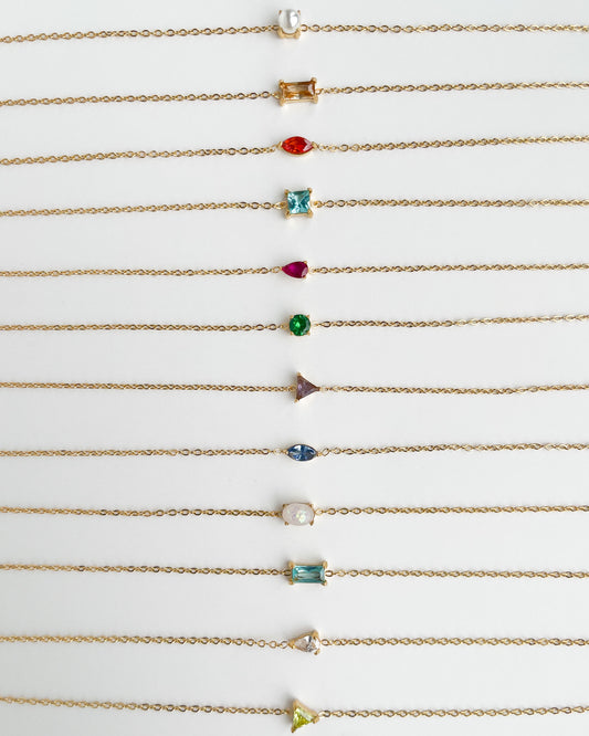 Gold bracelets with various colored gemstones on a white background, Jewelz Birthstone Bracelet