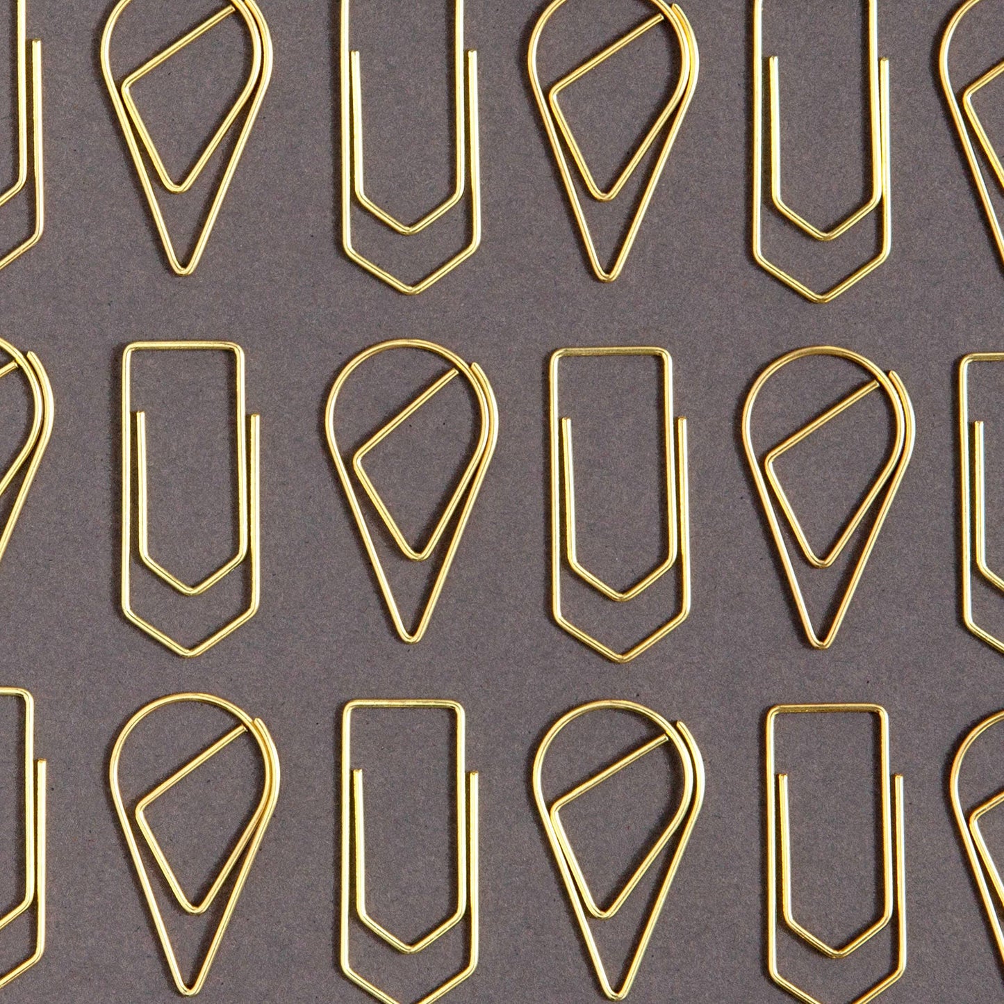 Pattern of gold paper clips on a gray background