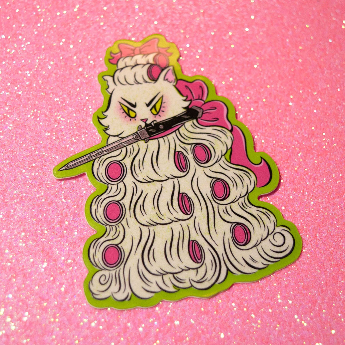 A die-cut sticker or pin featuring an anime-style white cat with yellow eyes, holding a katana, dressed in a long white wig with pink circular accents and a pink bow, set against a pink glitter background.