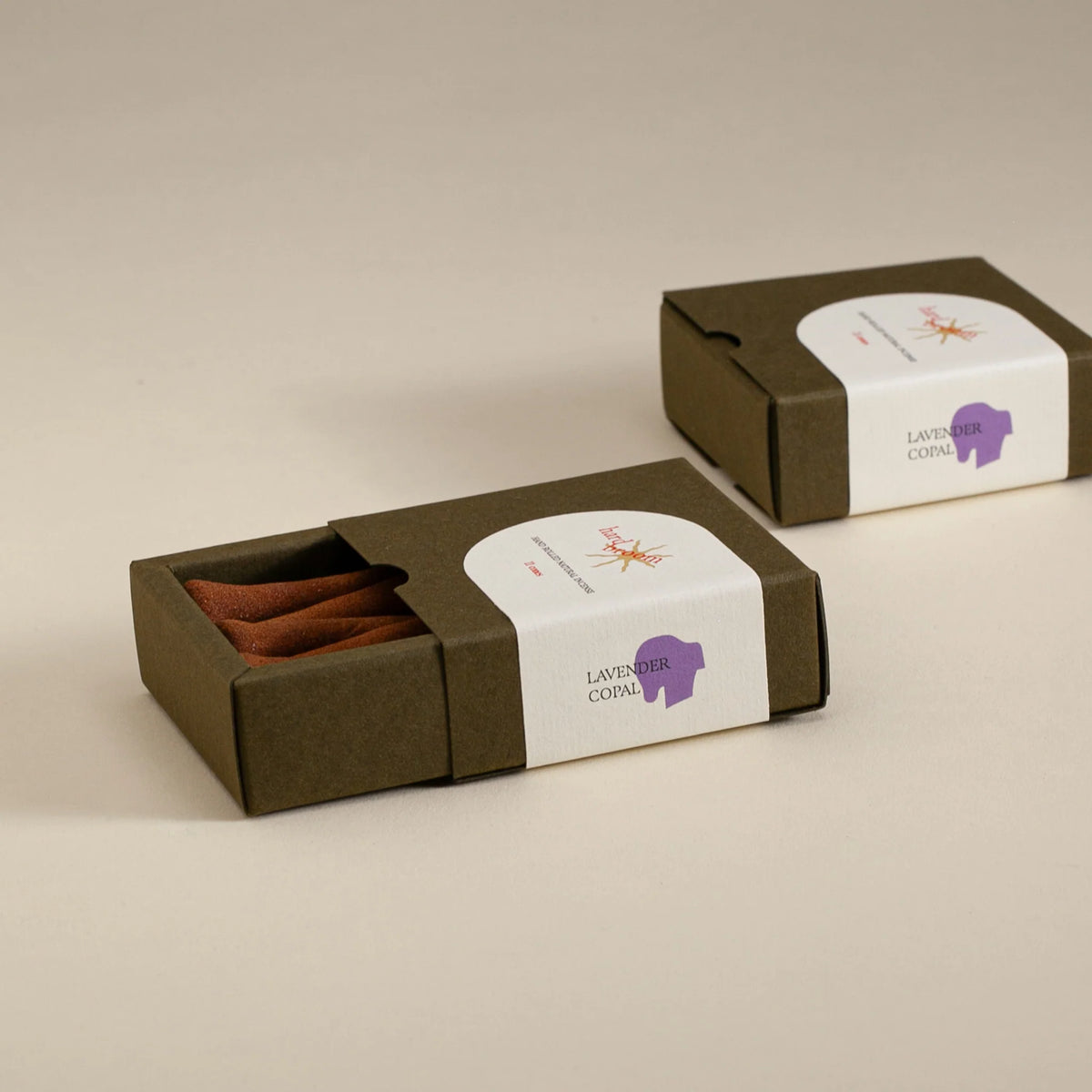 Two brown boxes with white labels on a beige background