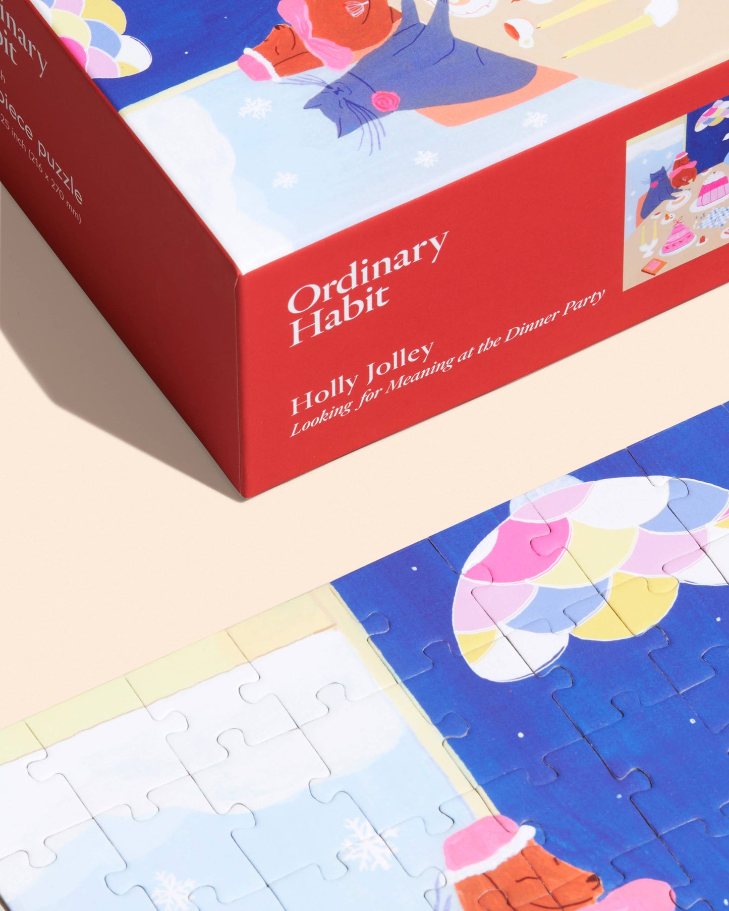 Jigsaw puzzle set with 'Ordinary Habit' and 'Holly Jolley' branding on a colorful background.