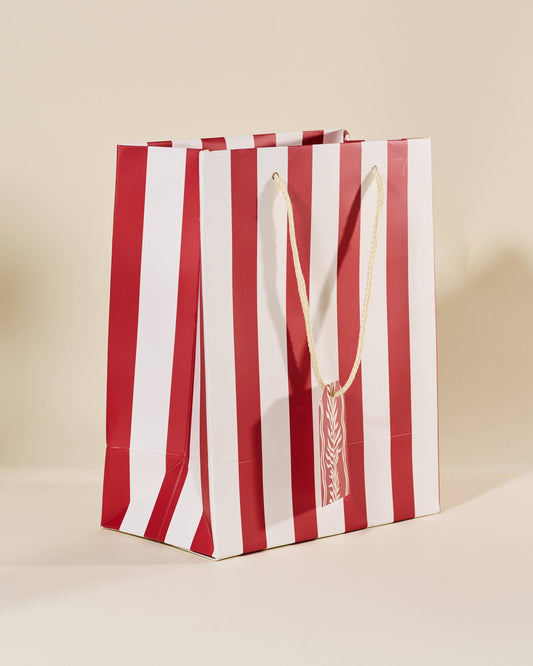 Red and white striped paper bag on a beige background