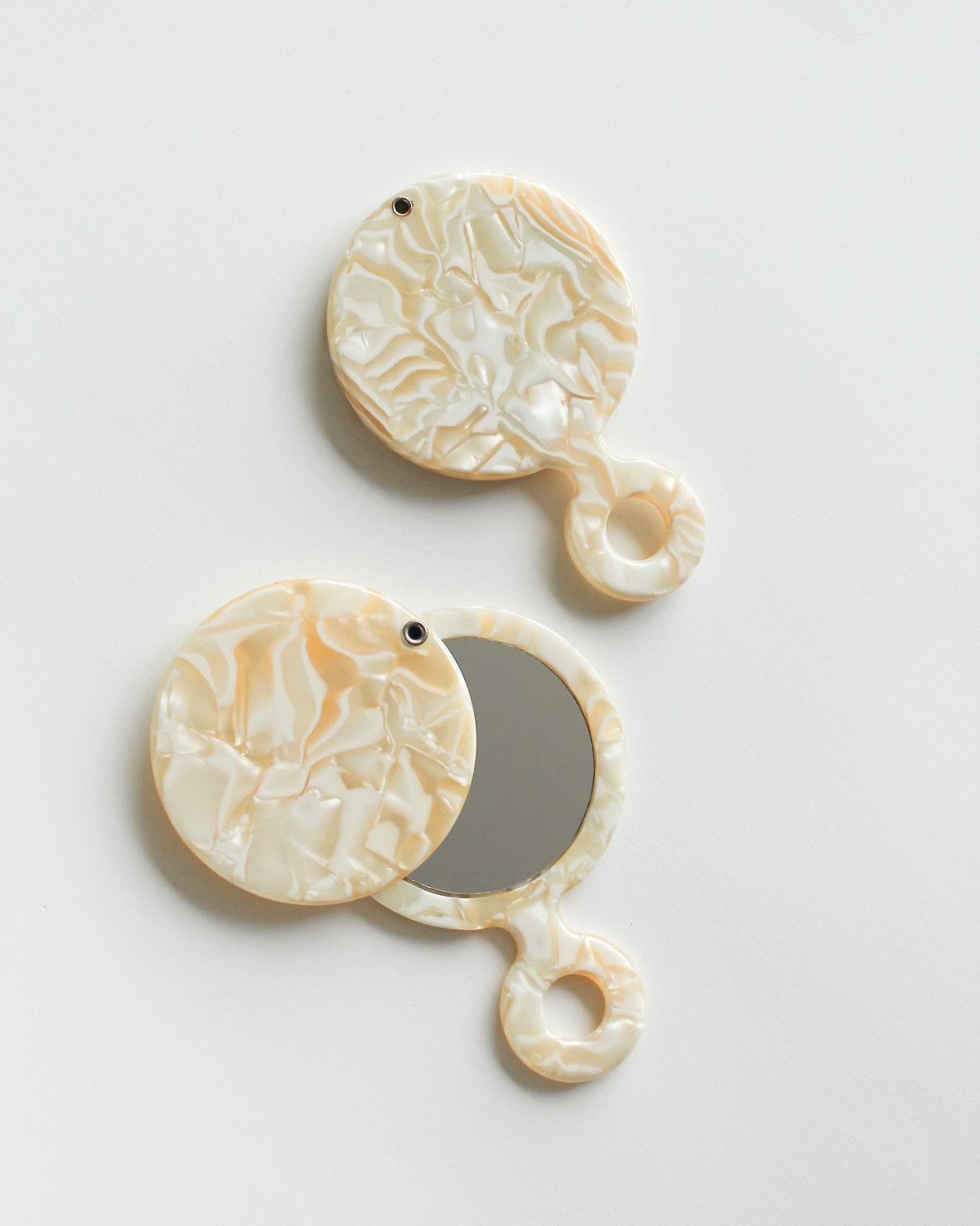 Swivel Pocket Mirror Pair of decorative earrings with circular designs on a light gray background