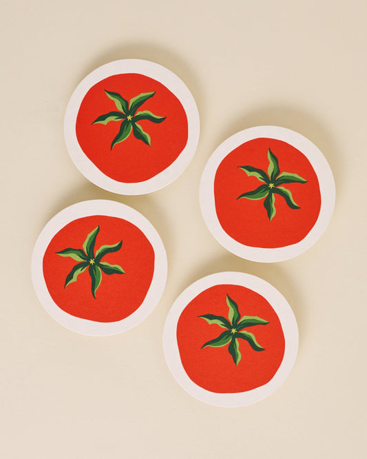 Four round coasters with tomato design on a beige background