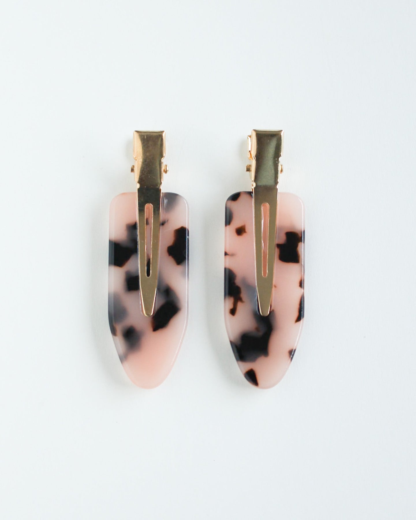 Pair of crease free hairclips with pink and black tortoise print design on a white background