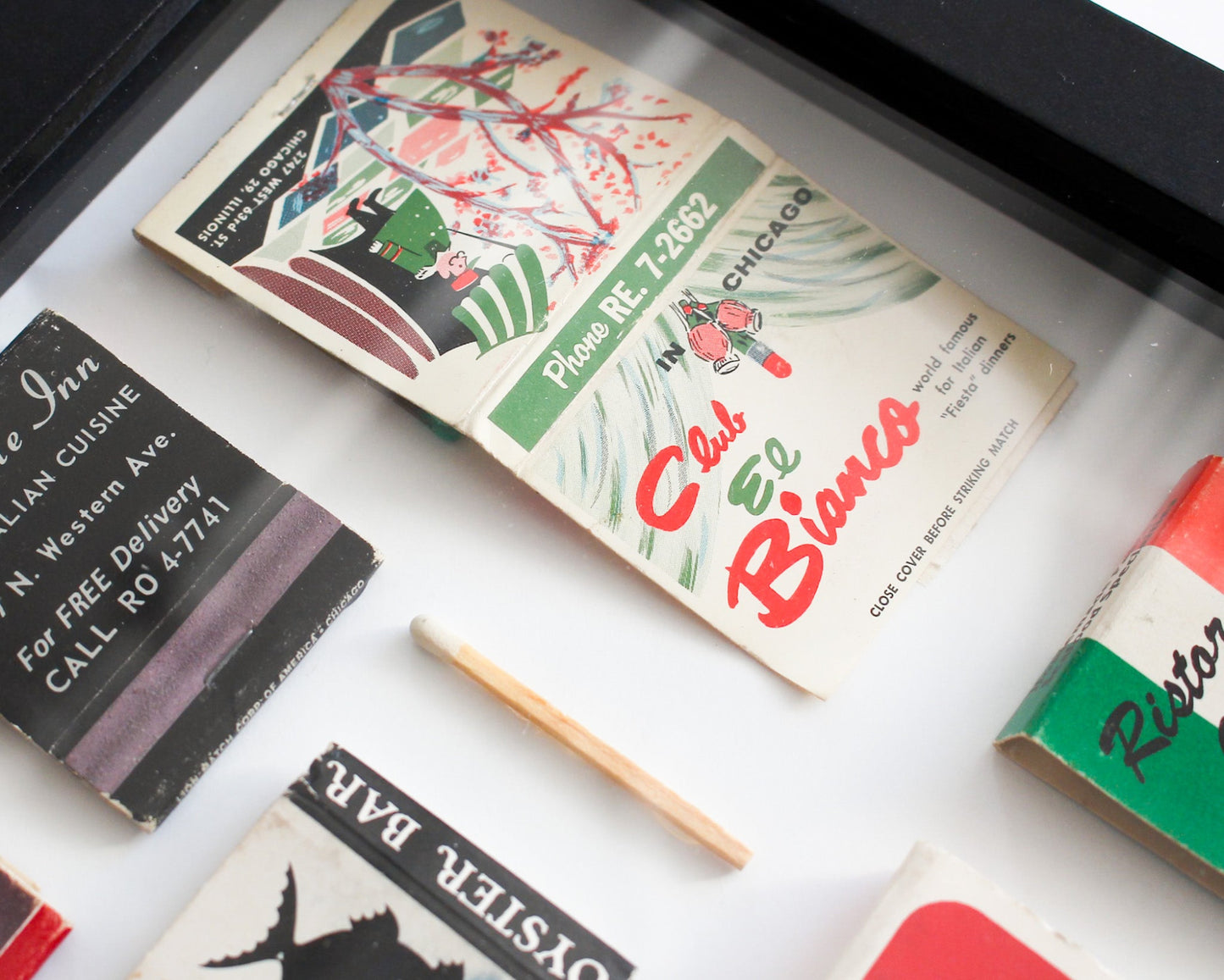 Collection of vintage matchbooks with colorful designs on a white surface