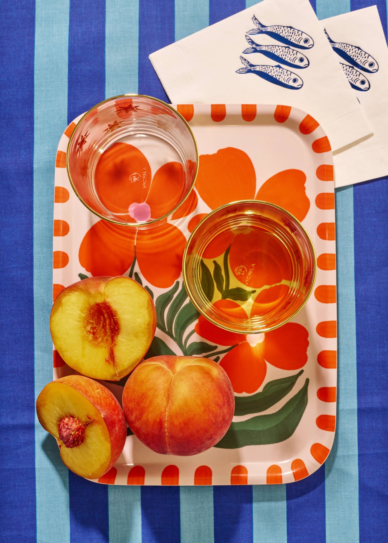 Decorative tray with peaches and glasses on a striped blue background. Wild Flower Serving Tray One & Only Paper
