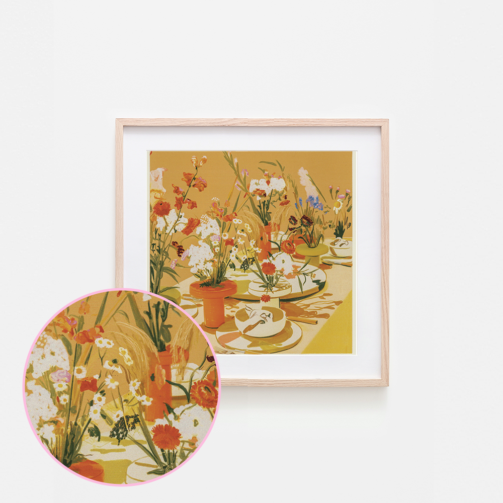 A framed art print featuring a vintage-style floral table scene in warm yellow, orange, white, and green tones, shown against a light gray background with a circular inset detail of the floral pattern.