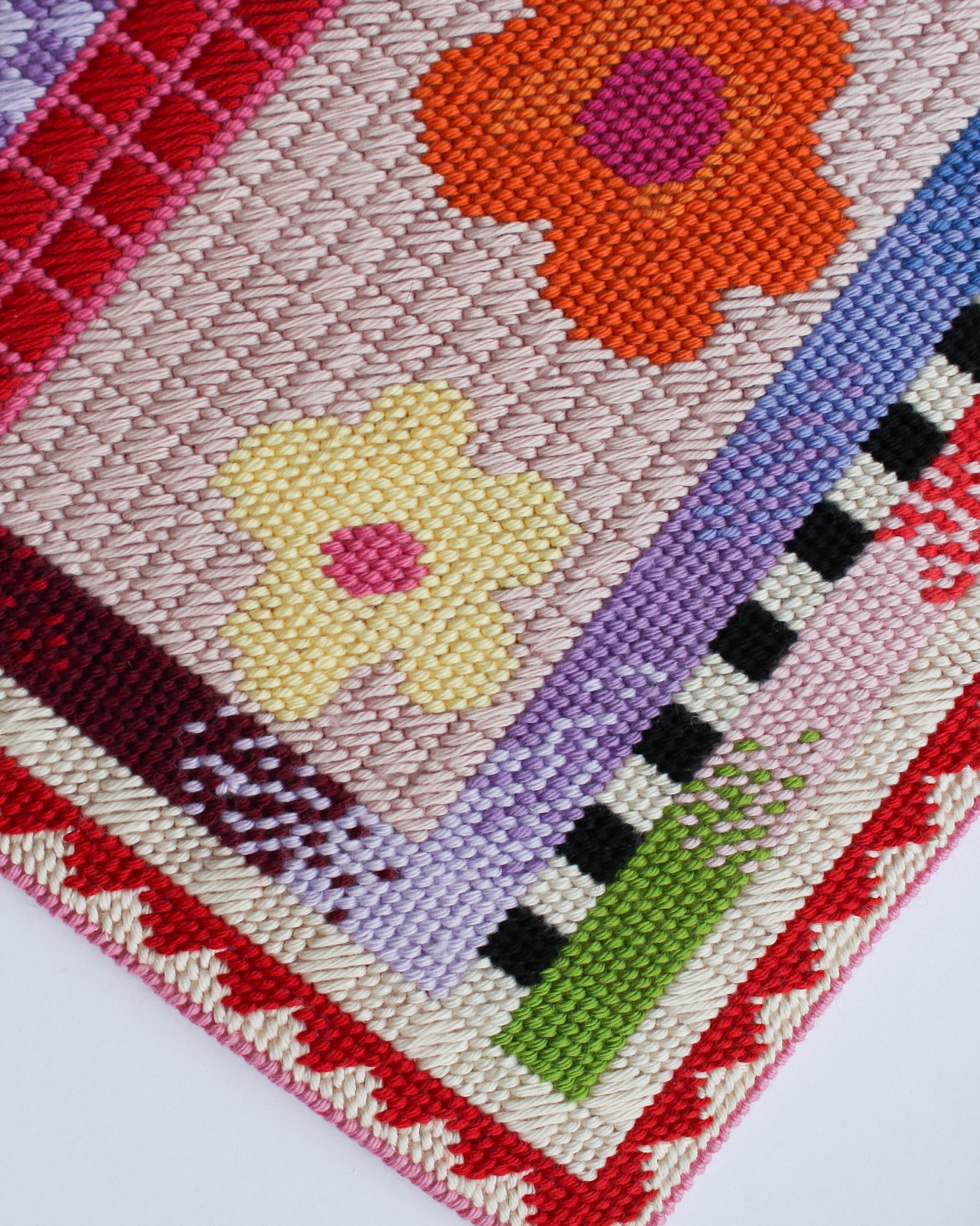 Close-up of a woven fabric with colorful flowers and patterns