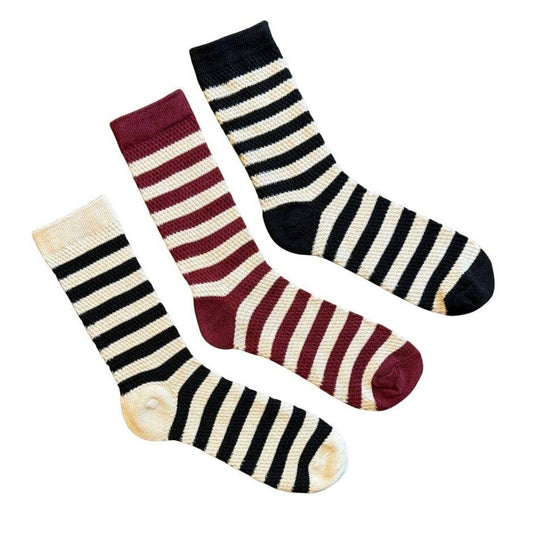 Three striped crew socks arranged diagonally on a white background: one cream and black, one cream and burgundy, and one cream and black with a burgundy toe.