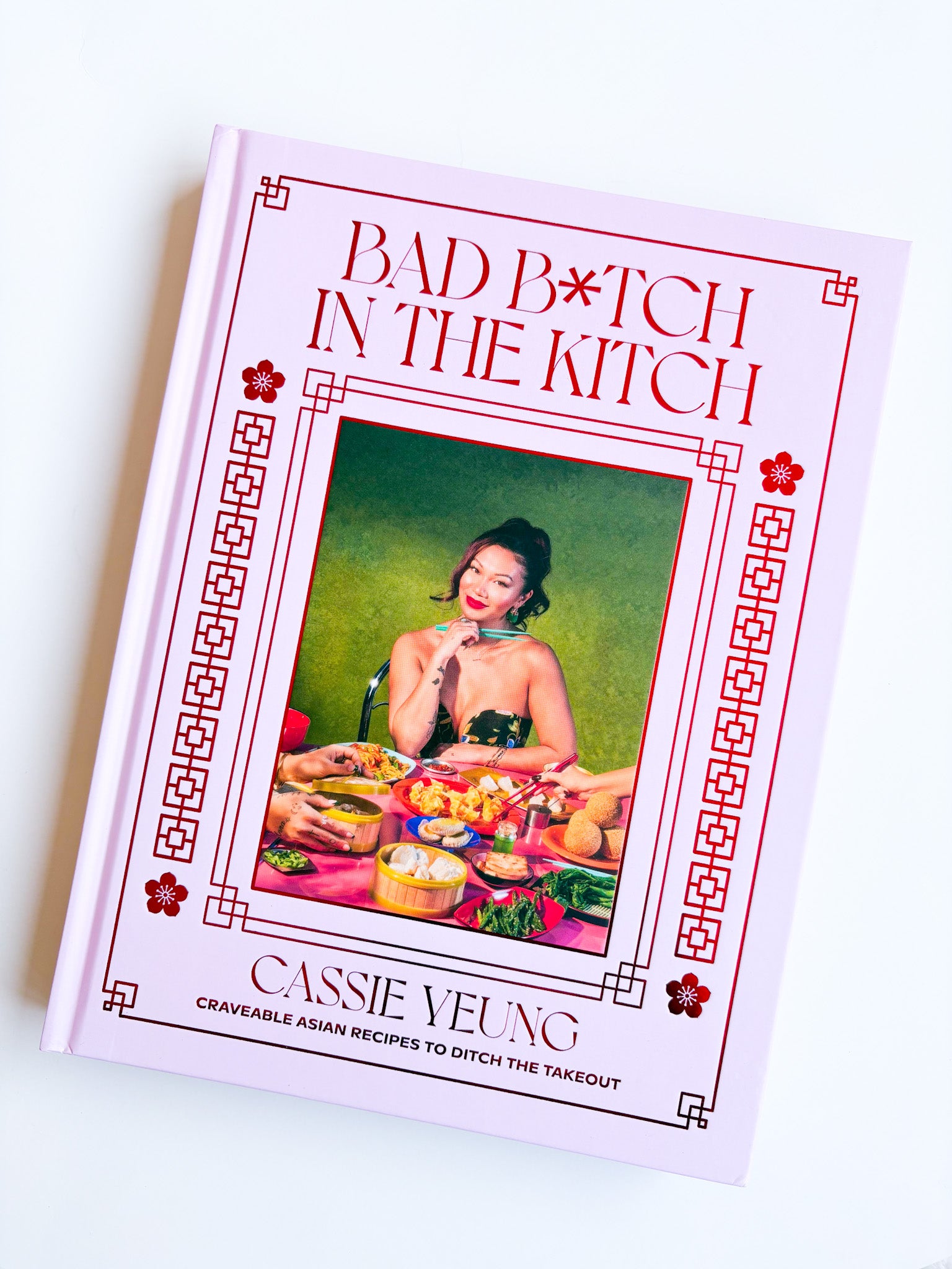 Cookbook titled 'Bad Bitch in the Kitch' by Cassie Yeung on a white background