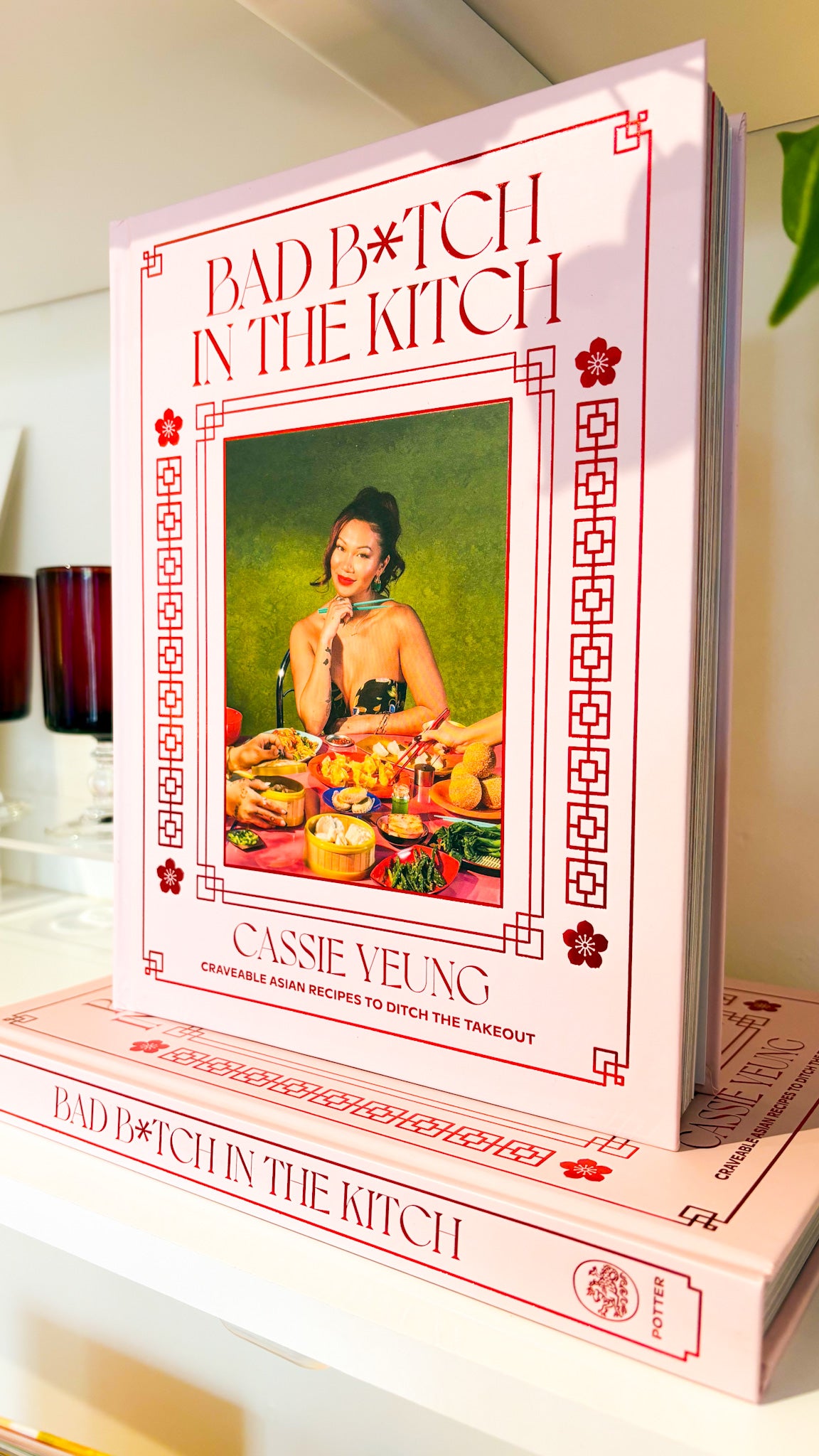 Cookbook titled 'Bad Bitch in the Kitch' by Cassee Yeung on a white surface.