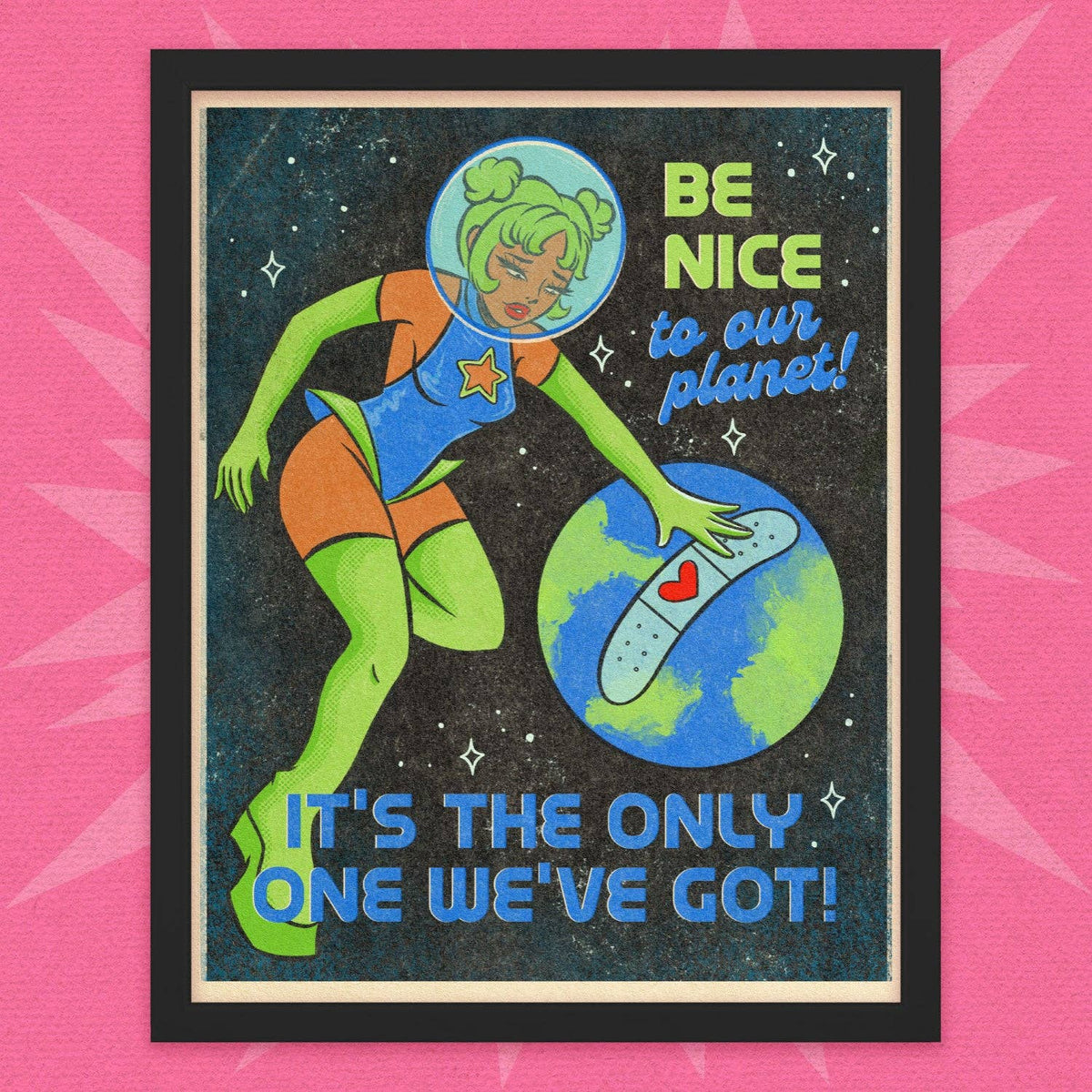 A framed retro-futuristic art print featuring a cartoon space-themed figure in a blue and orange bodysuit touching a blue and green planet with a bandage on it. The text reads 'BE NICE to our planet! IT'S THE ONLY ONE WE'VE GOT!' on a pink background.