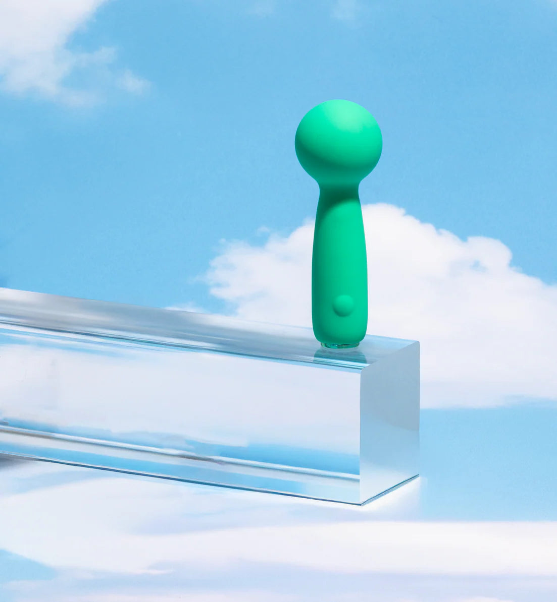 Green handheld device on a clear stand against a blue sky with clouds