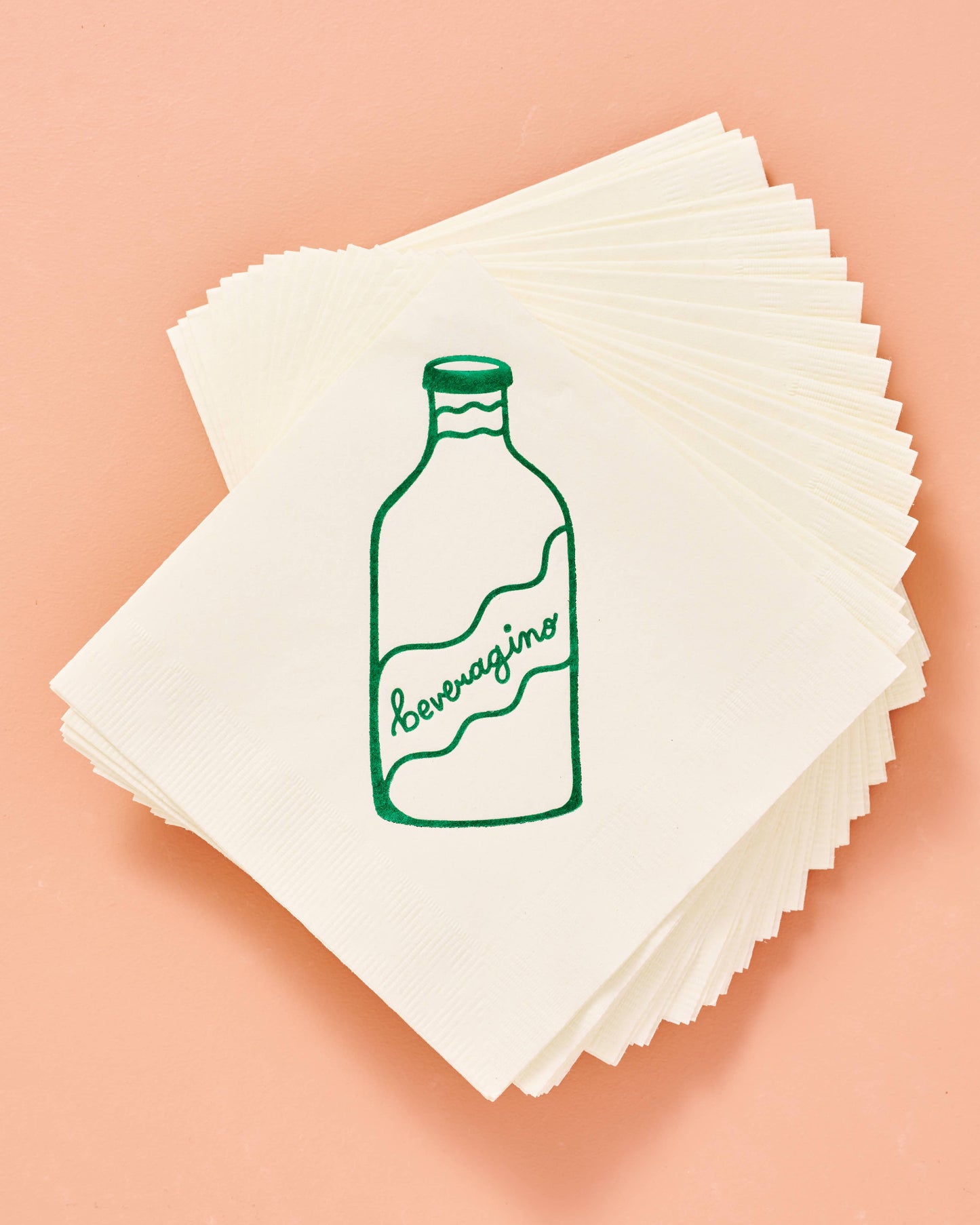 Stack of white napkins with green bottle illustration on a peach background. Beveragino Green and White Paper Cocktail Napkins