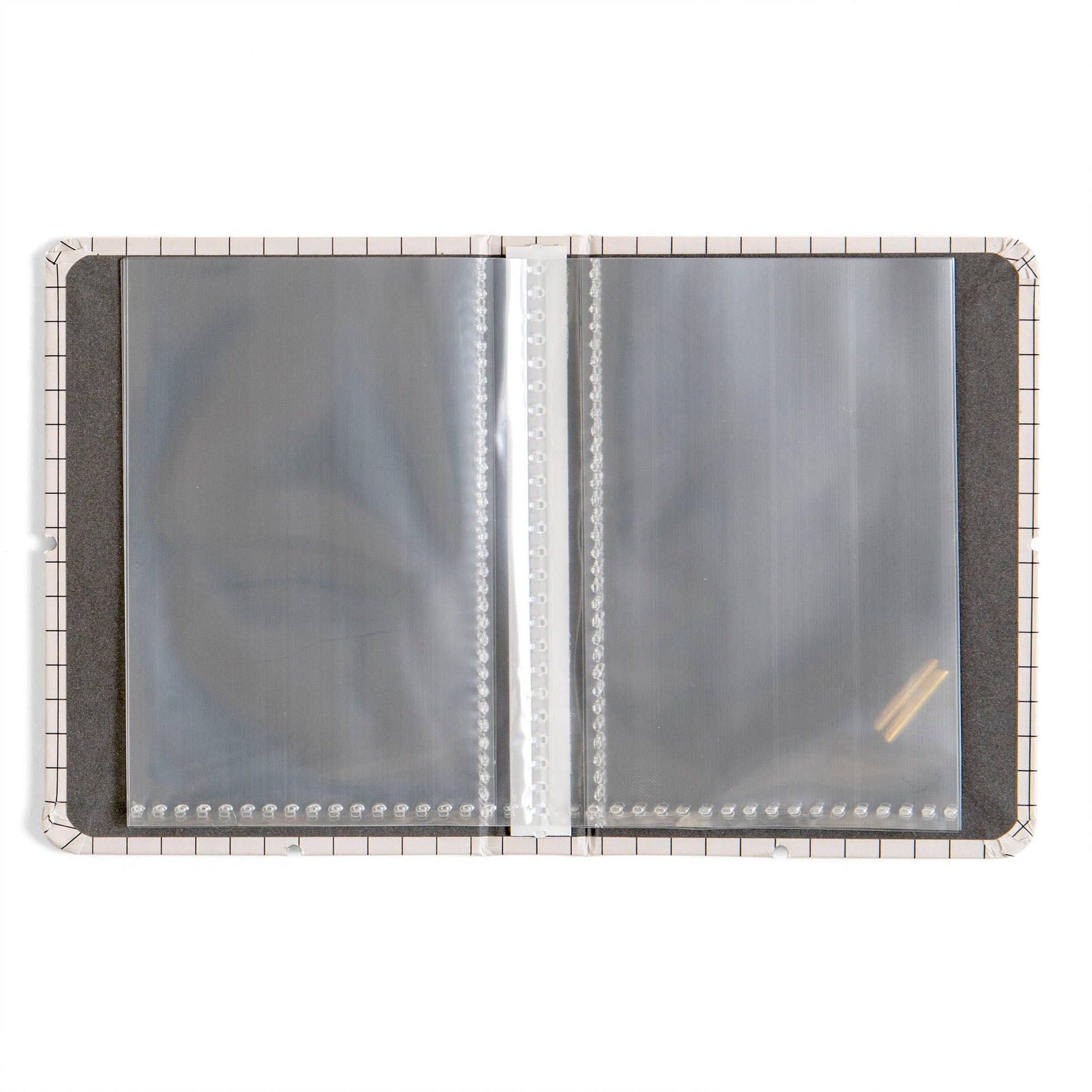 An open plastic binder or album page protector cover with clear plastic sleeves on a white background.