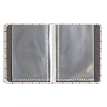An open plastic binder or album page protector cover with clear plastic sleeves on a white background.