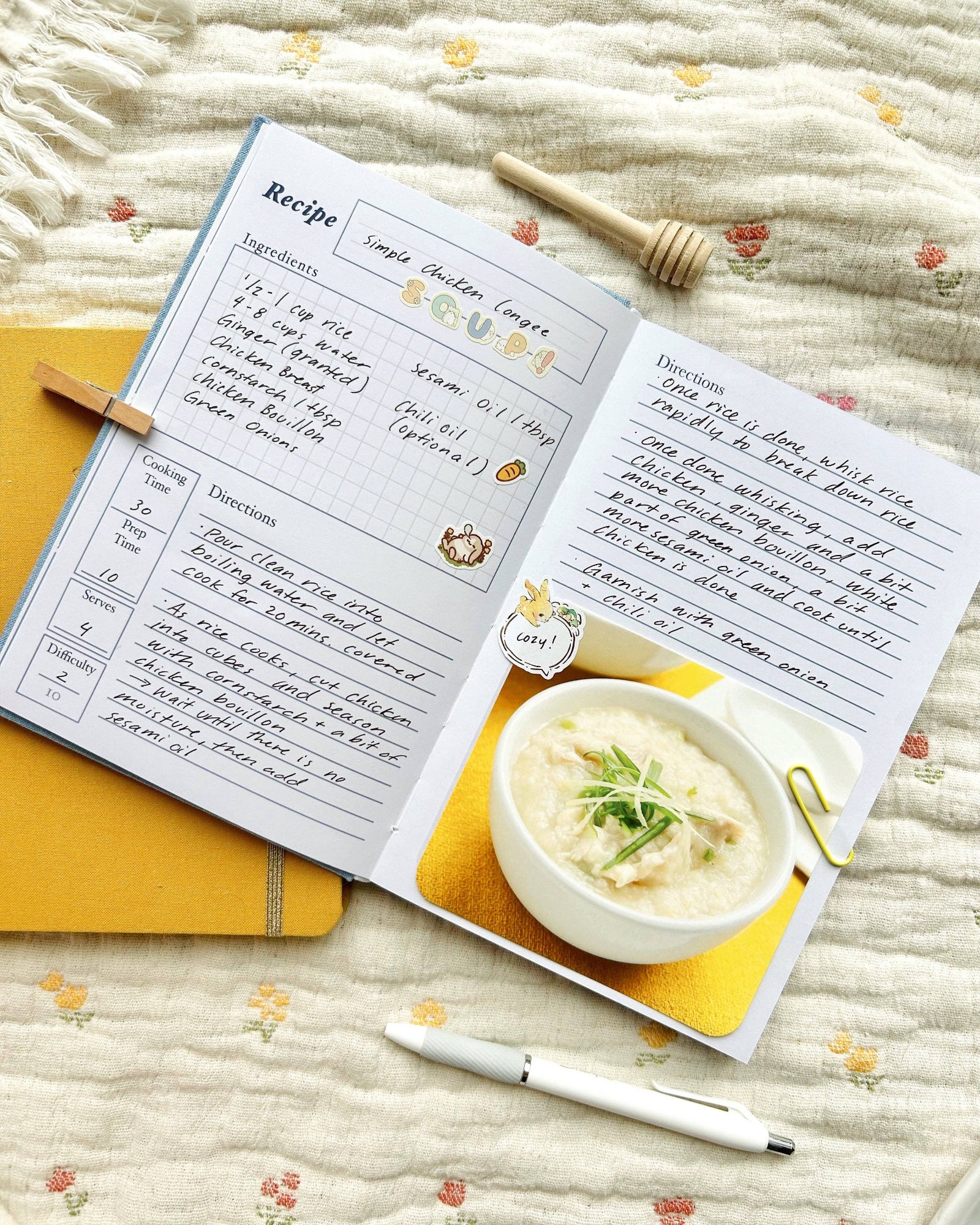 Open recipe book with a bowl of soup on a textured surface