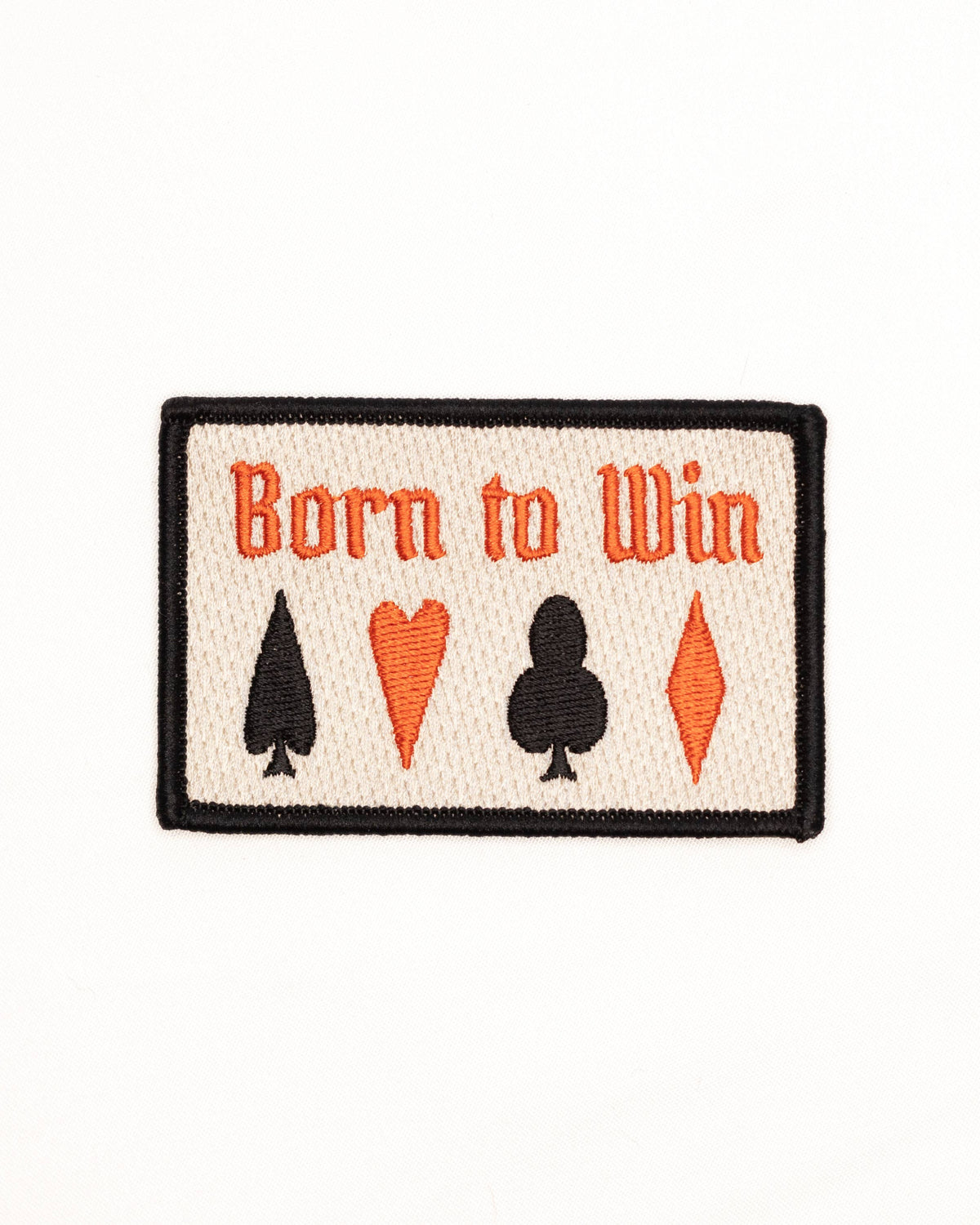 Patch with 'Born to Win' text and card suit symbols on a white background