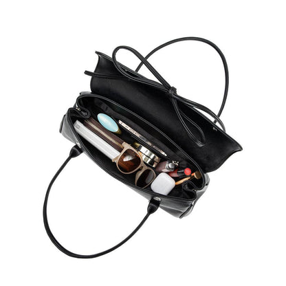 Black handbag with its interior open, showing various items on a white background, Bowie Shoulder Bag, Melie Bianco