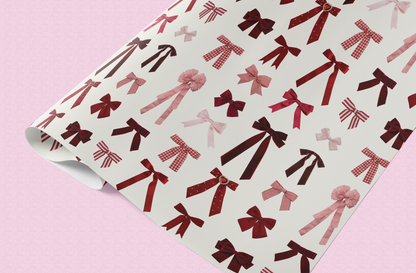 Roll of paper with red and pink bow pattern on a pink background