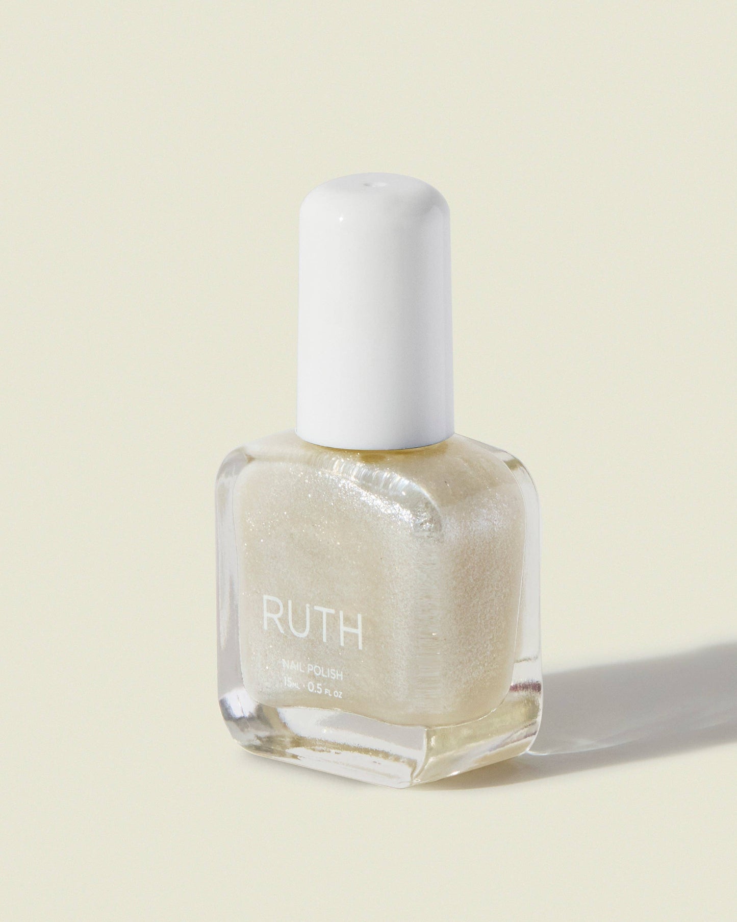 Nail polish bottle with 'RUTH' branding on a light beige background, Bride Pearl Nail Polish
