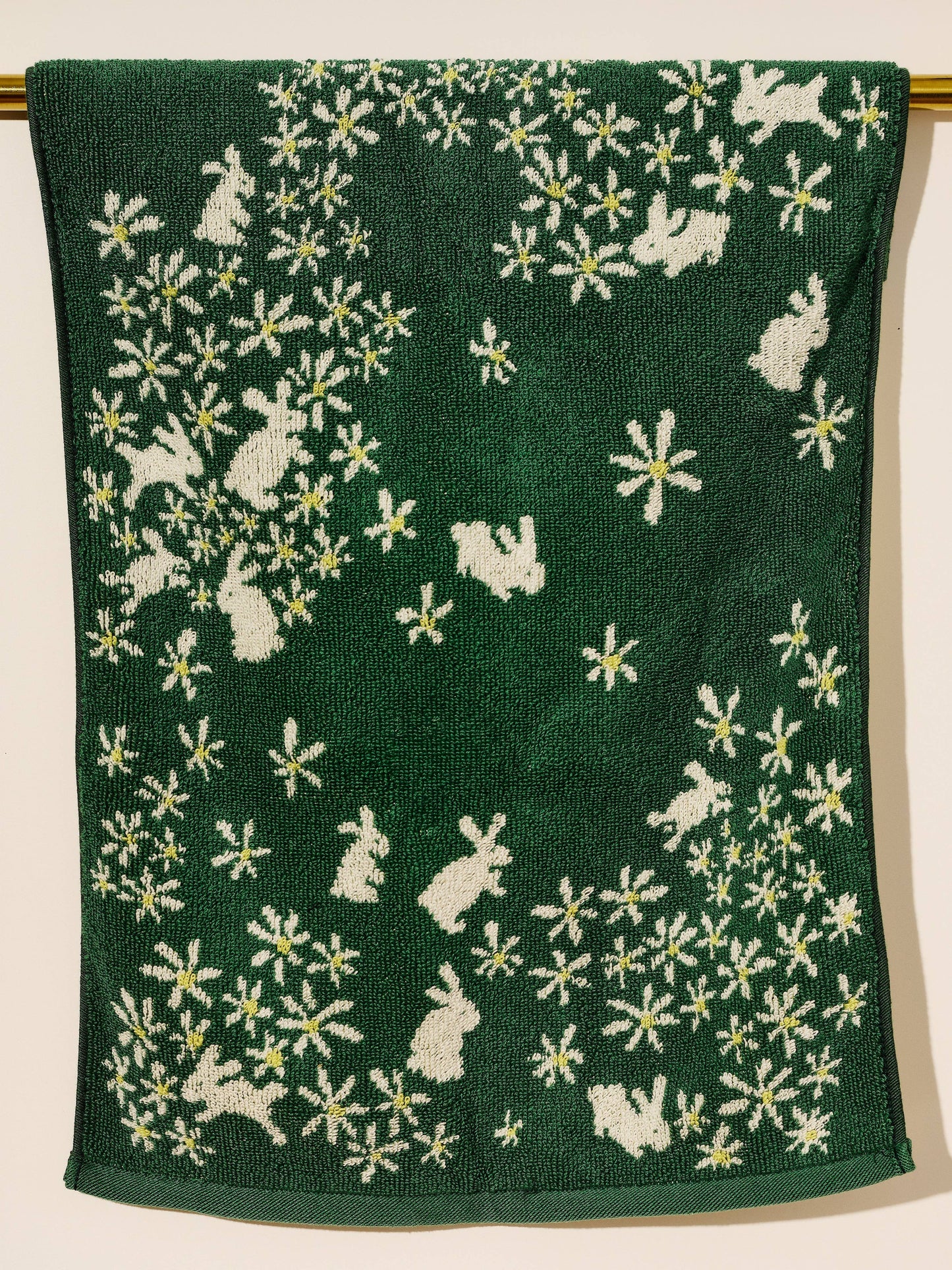 Green towel with white floral and rabbit pattern