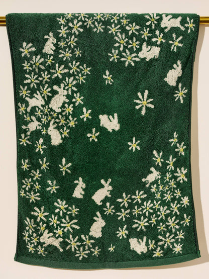 Green towel with white floral and rabbit pattern