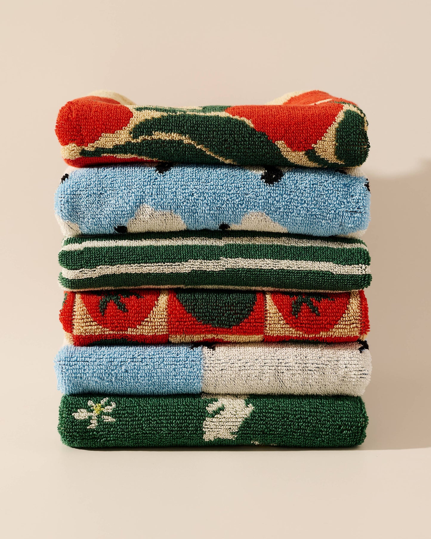 Stack of colorful folded towels on a neutral background
