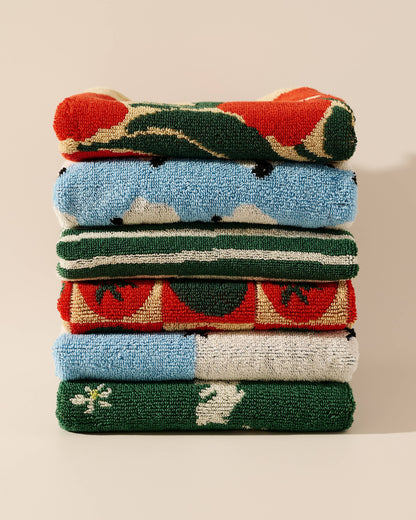 Stack of colorful folded towels on a neutral background