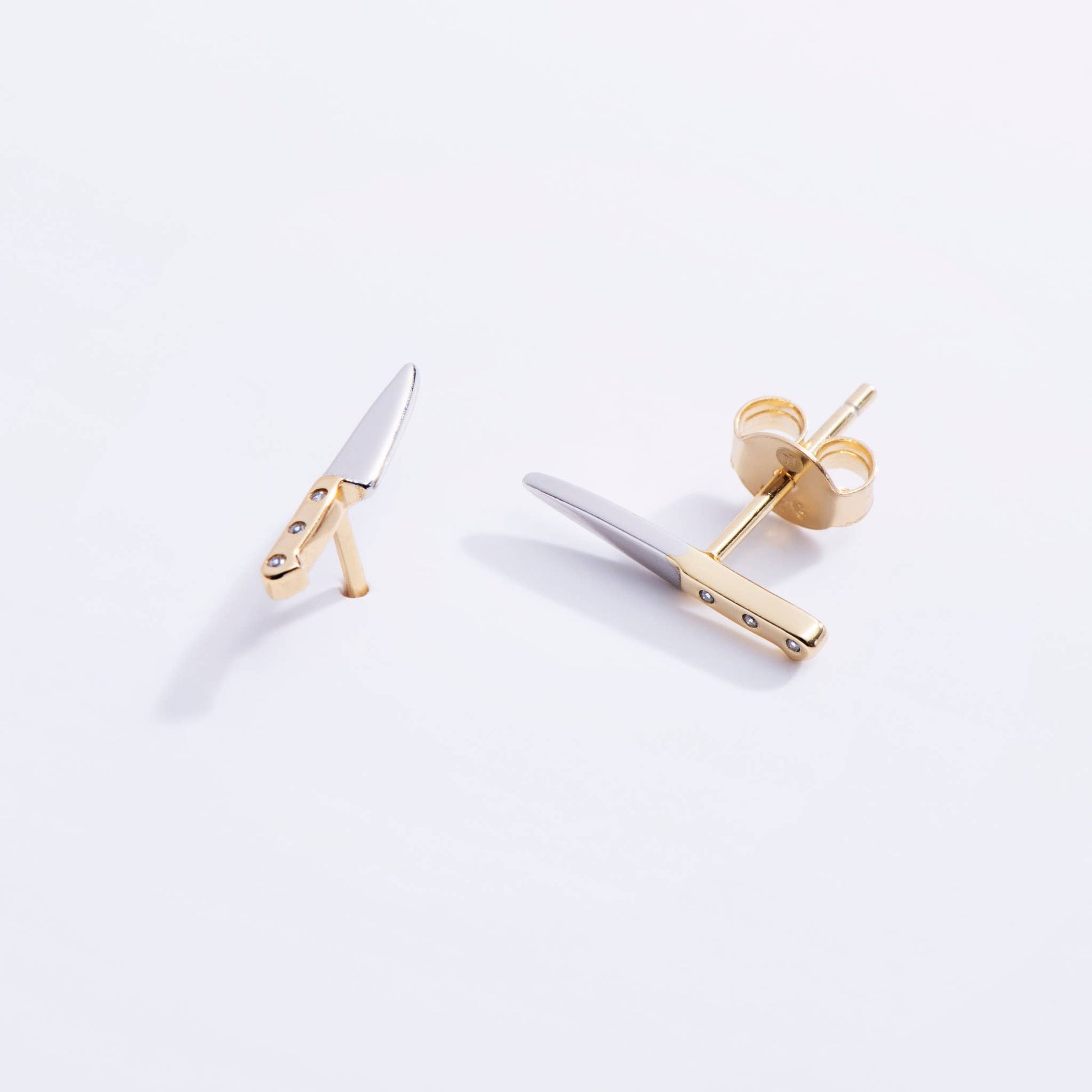 Gold and silver earrings on a white background