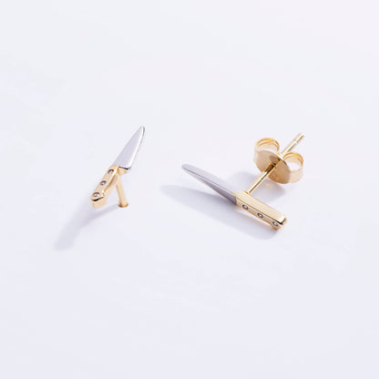 Gold and silver earrings on a white background